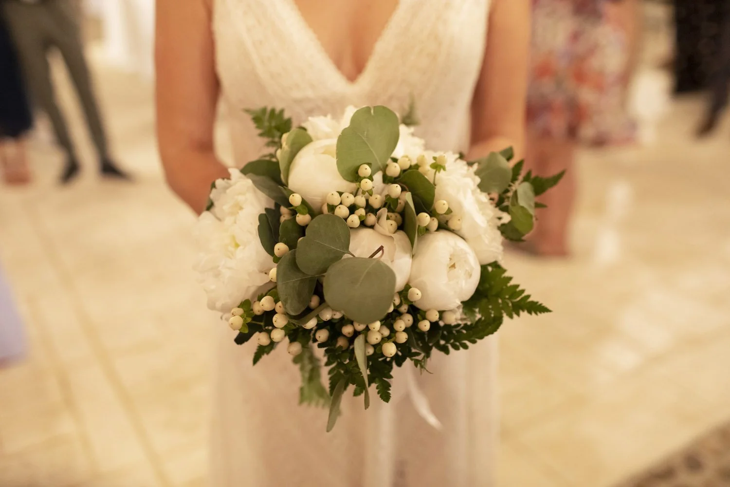 Bride holding a romantic white wedding bouquet with peonies, eucalyptus, and greenery during a Sicily destination wedding.