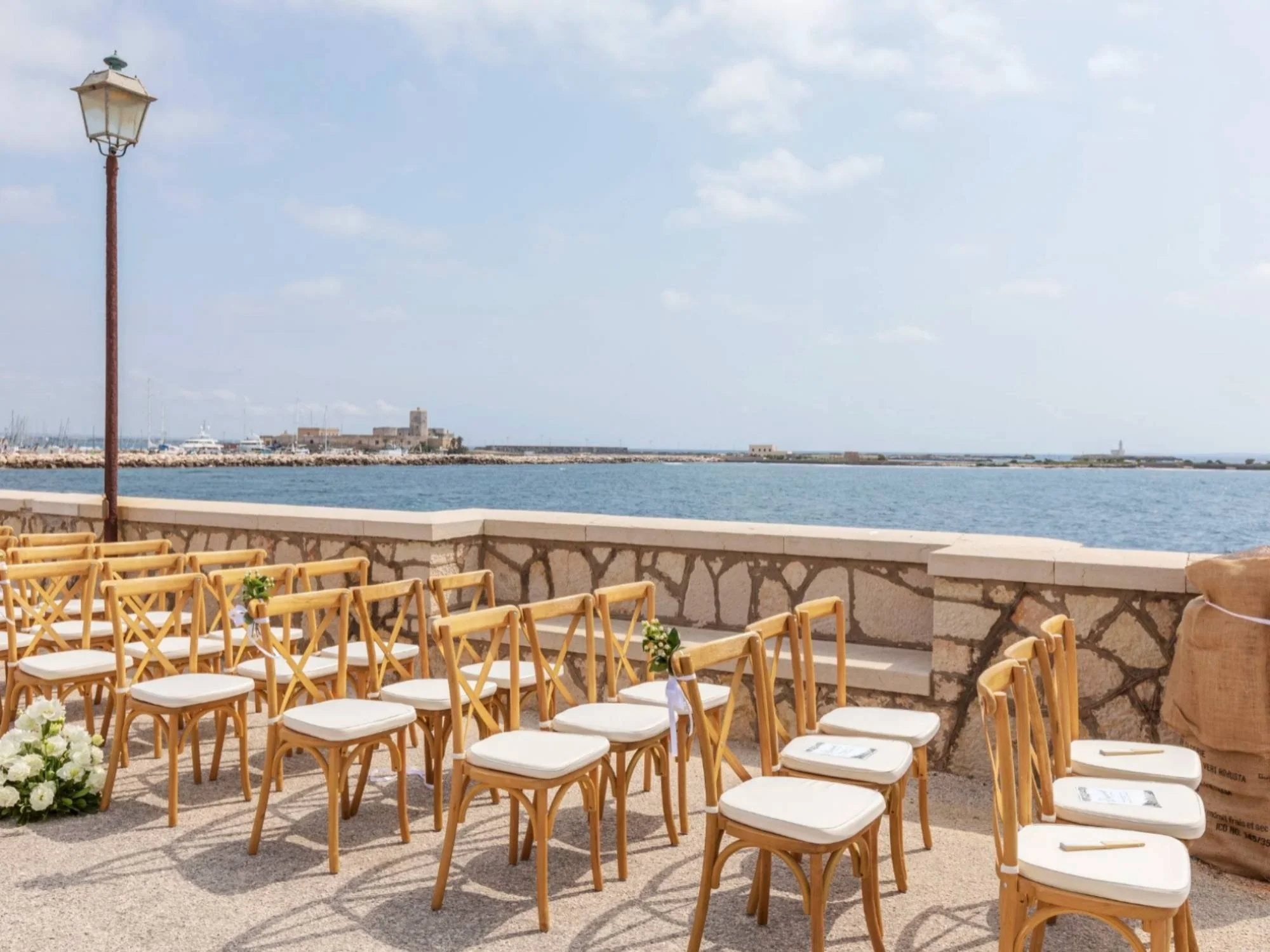Elegant ceremony chairs set up along the seafront in Trapani, ready for a coastal Sicilian wedding.