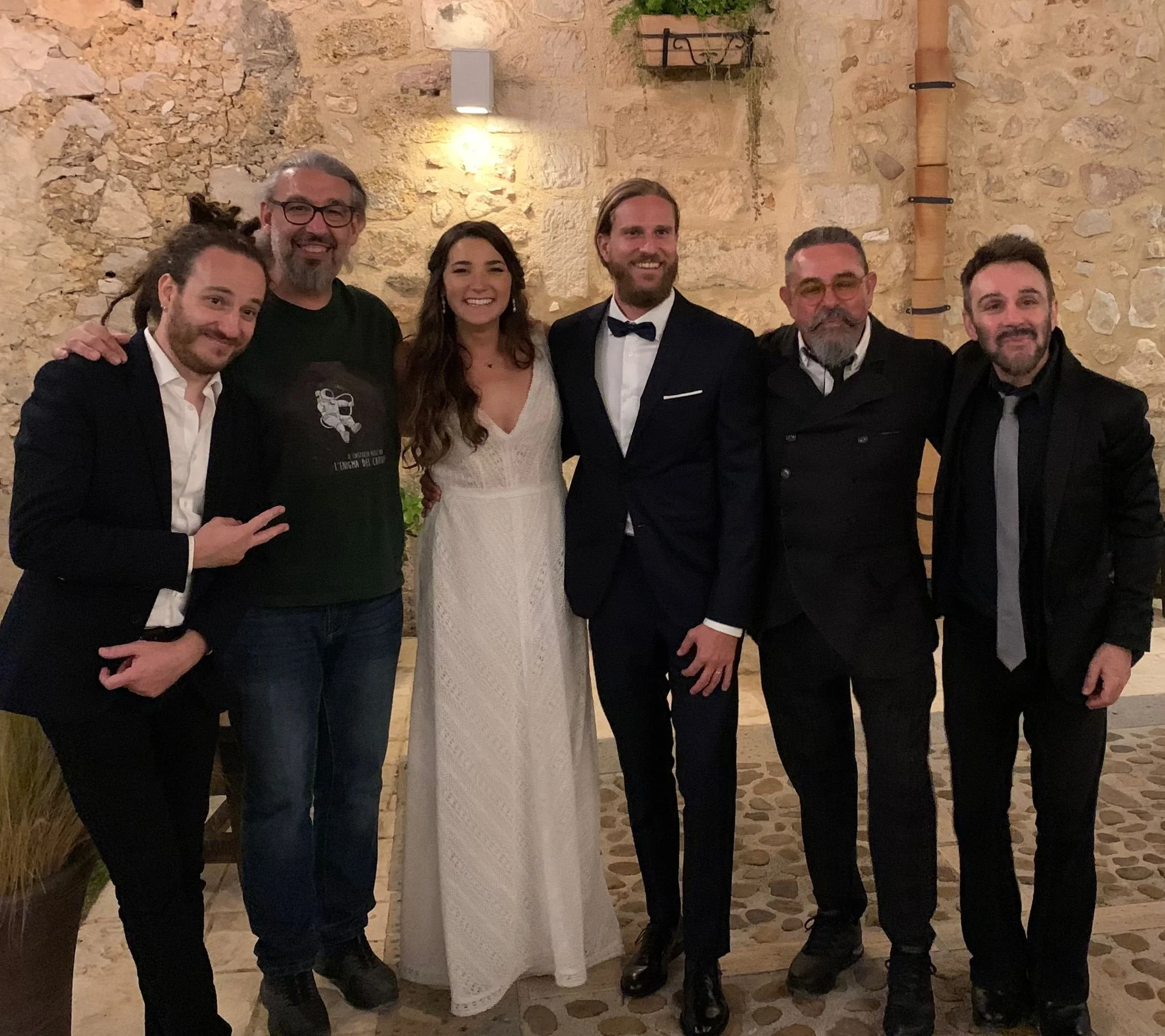 Bride and groom posing with Riccardo and his live wedding band after a destination wedding in Sicily.