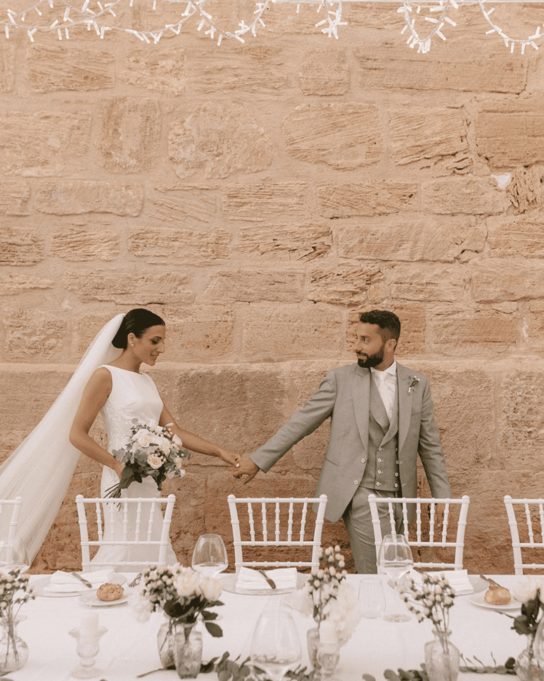 Romantic Sicily wedding reception courtyard with bride and groom at elegant long table