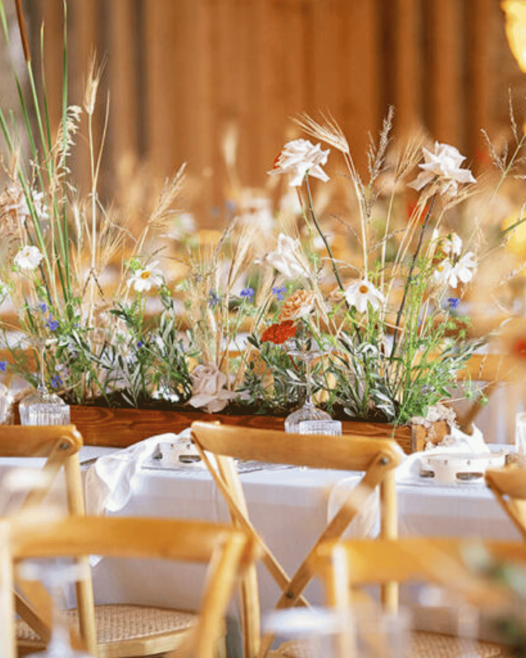 Elegant wedding table styling featuring wildflower centrepieces, soft pastel blooms, and rustic décor at a destination wedding reception in Sicily, Italy.