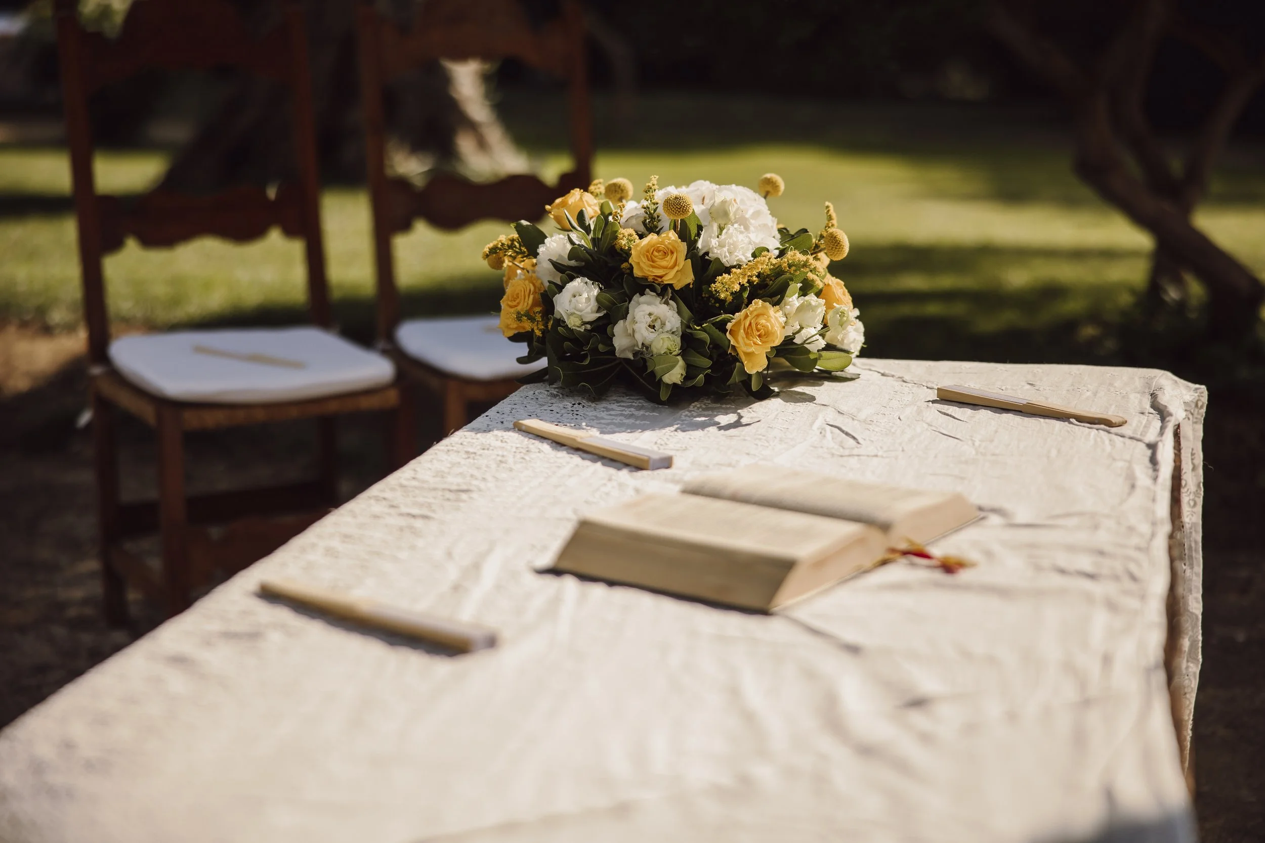Elegant outdoor wedding ceremony table with yellow and white floral styling by Alla Flora Giapponese in Sicily.