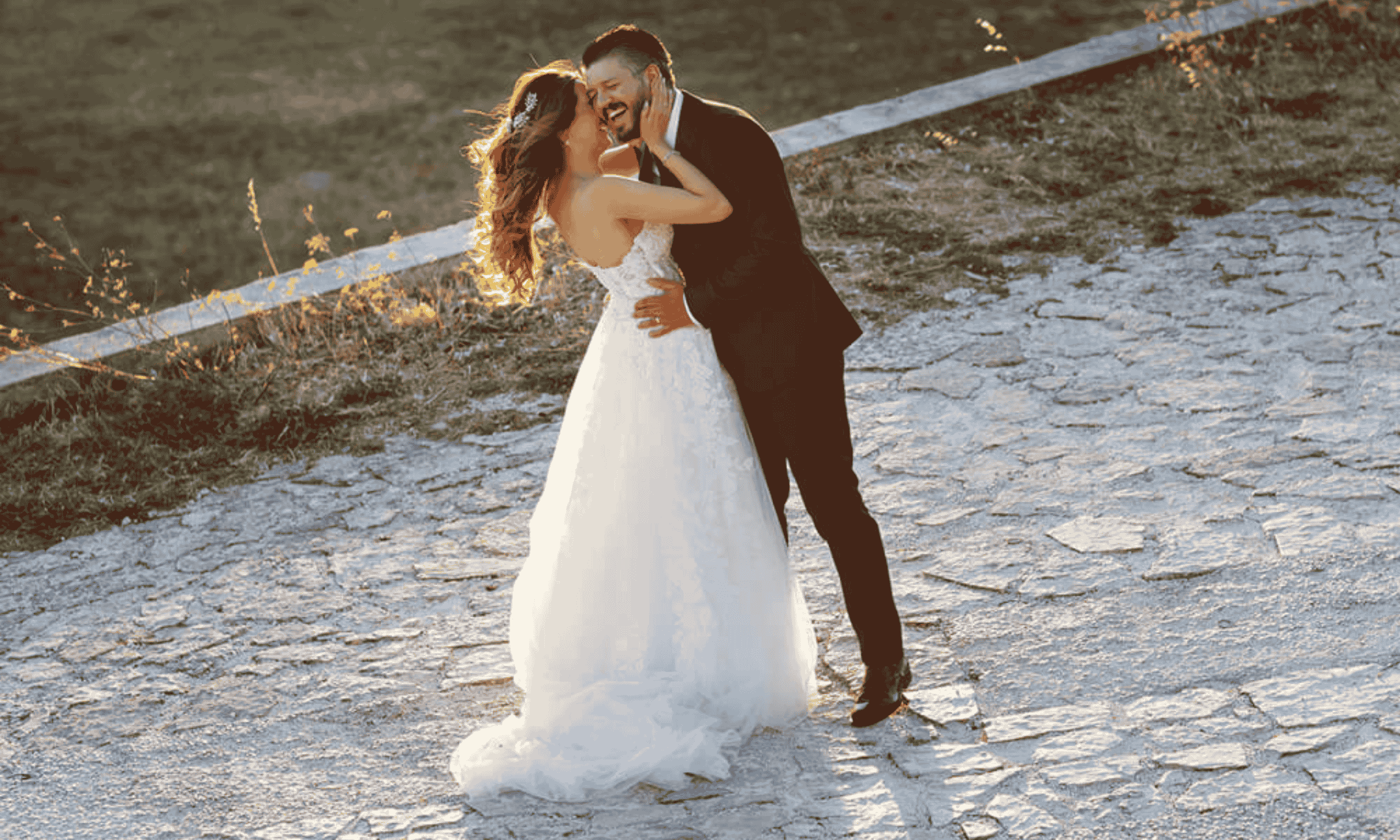 Bride and groom embracing and laughing during golden hour on a countryside path in Italy, romantic wedding portrait