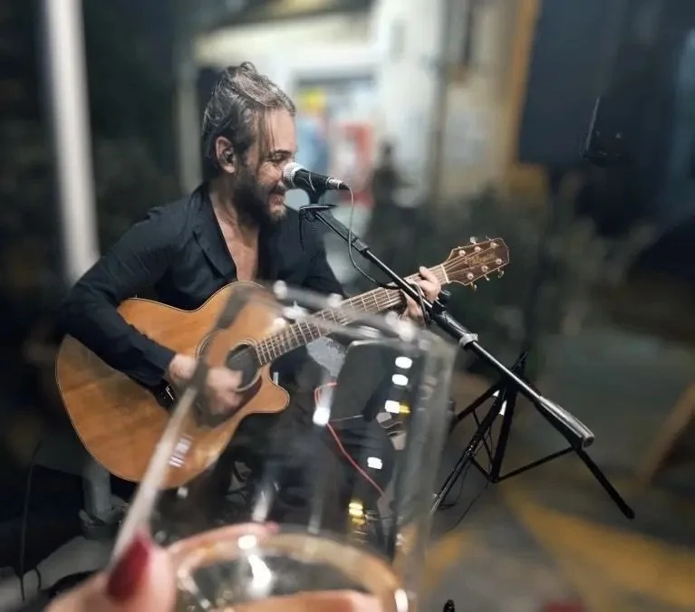 Riccardo performing acoustic guitar and vocals during an intimate wedding celebration in Sicily.