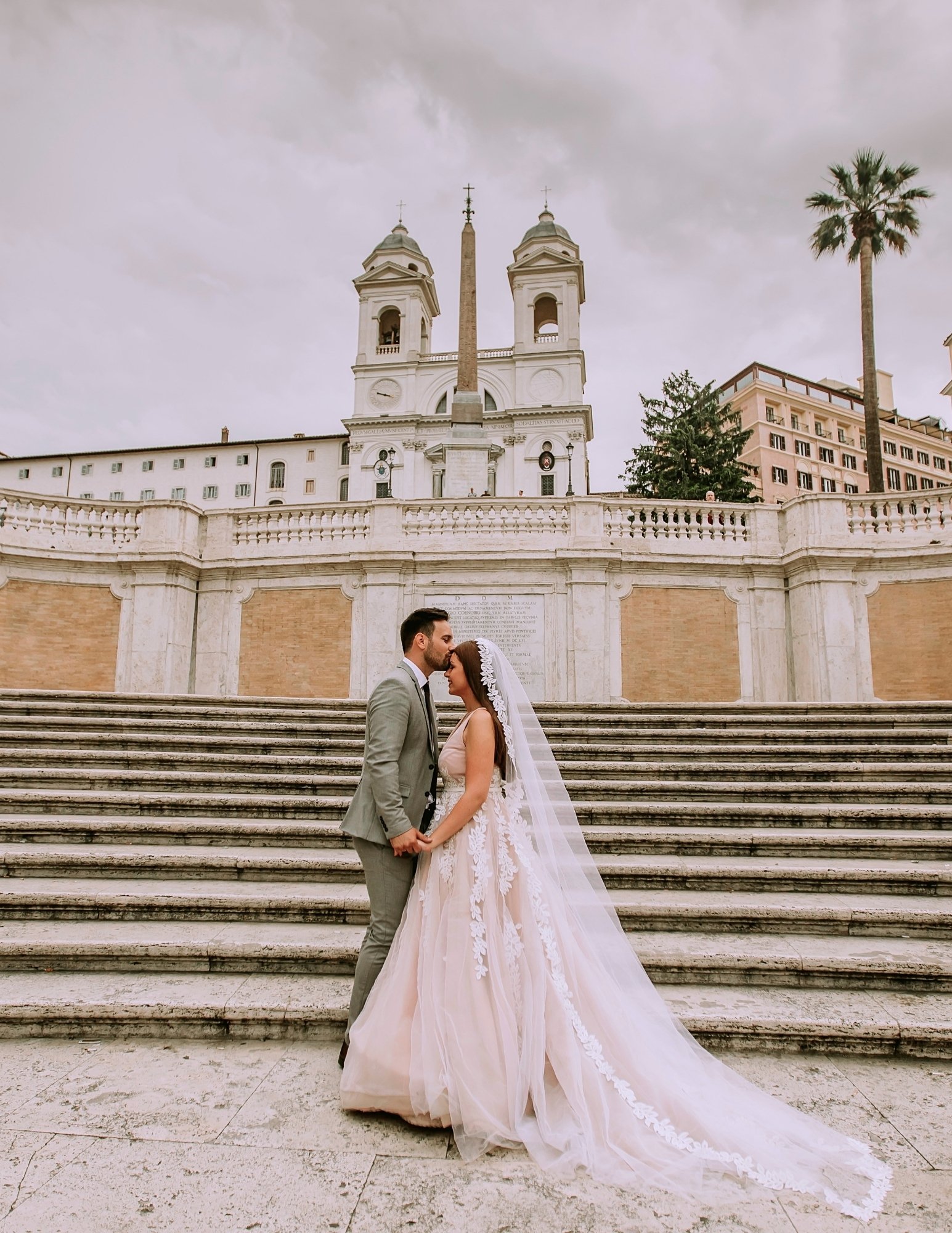 Bride and groom standing on historic stone steps in Rome during an Italy wedding portrait session.