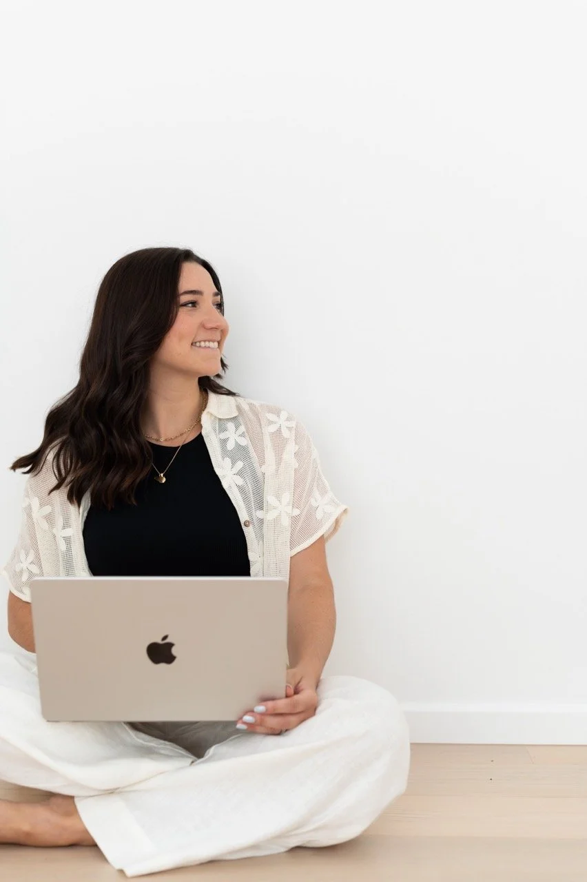 Elisa, founder of Italy Wedding Guide, smiling while working on her laptop — helping Australian couples plan their dream weddings in Italy.