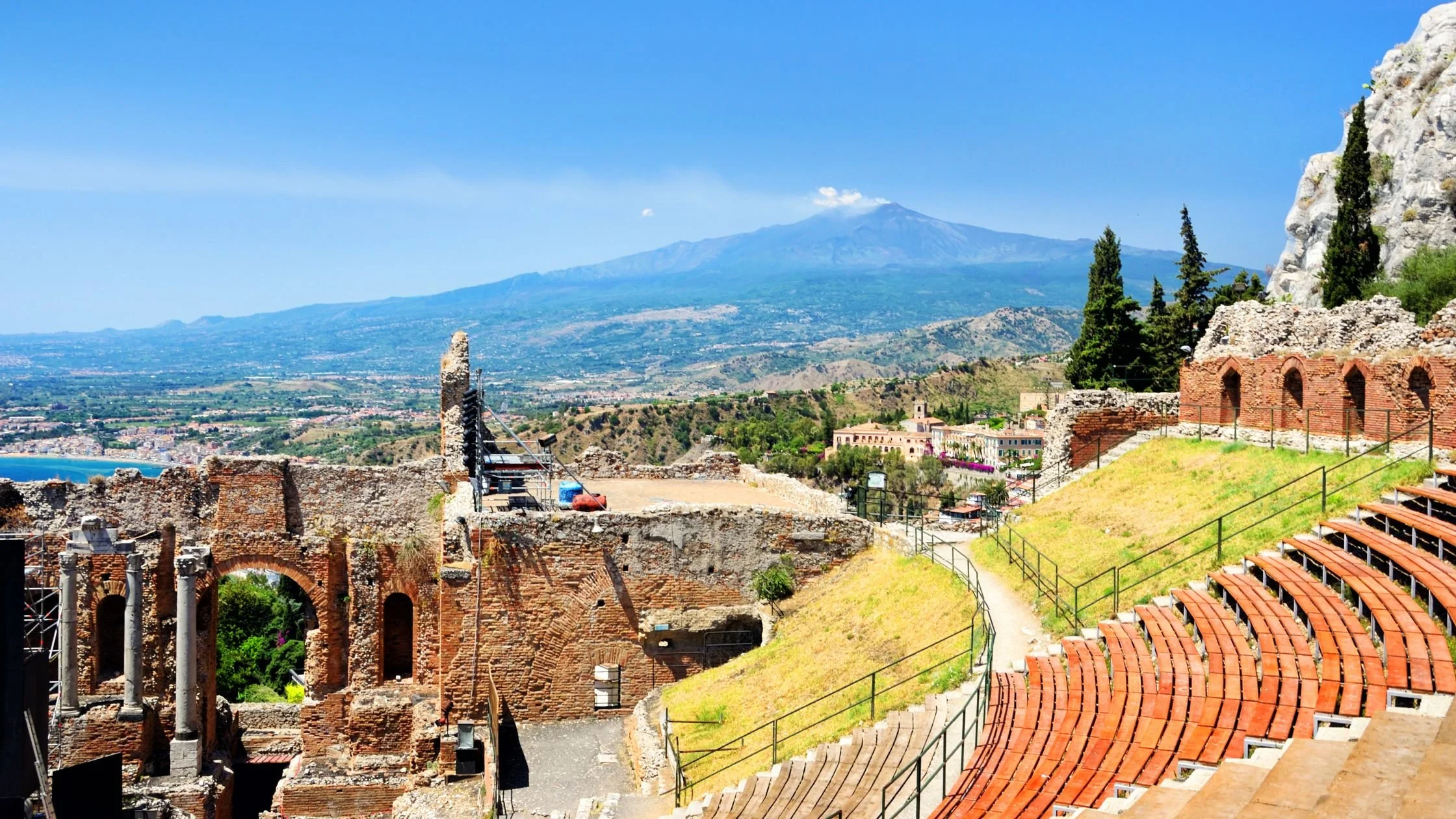 "Ancient Greek Theatre in Taormina, Sicily, overlooking the Mediterranean coast with Mount Etna in the background.