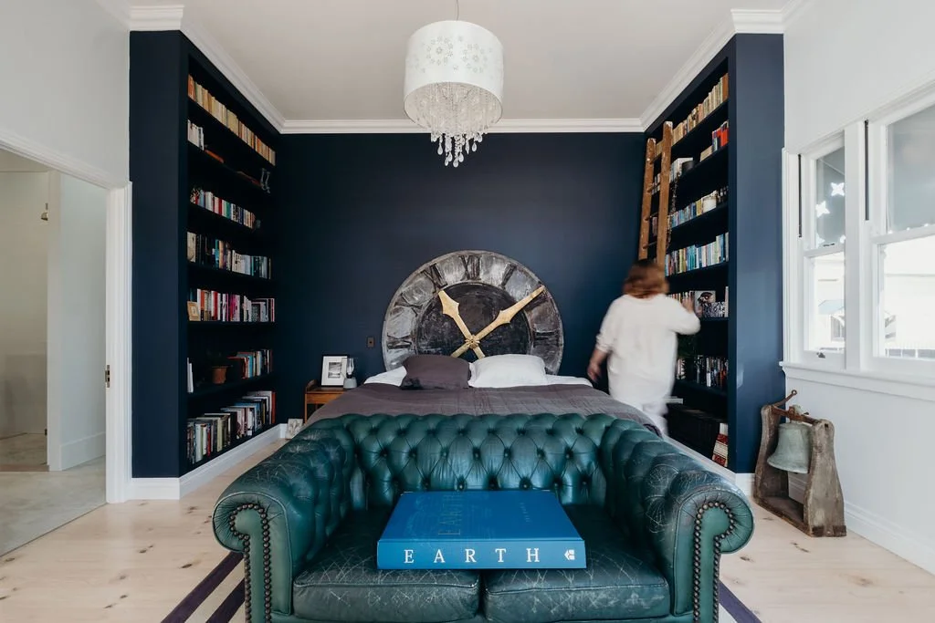 Character-inspired bedroom with navy feature wall and built-in shelving, renovated by Hill House Design & Construct.