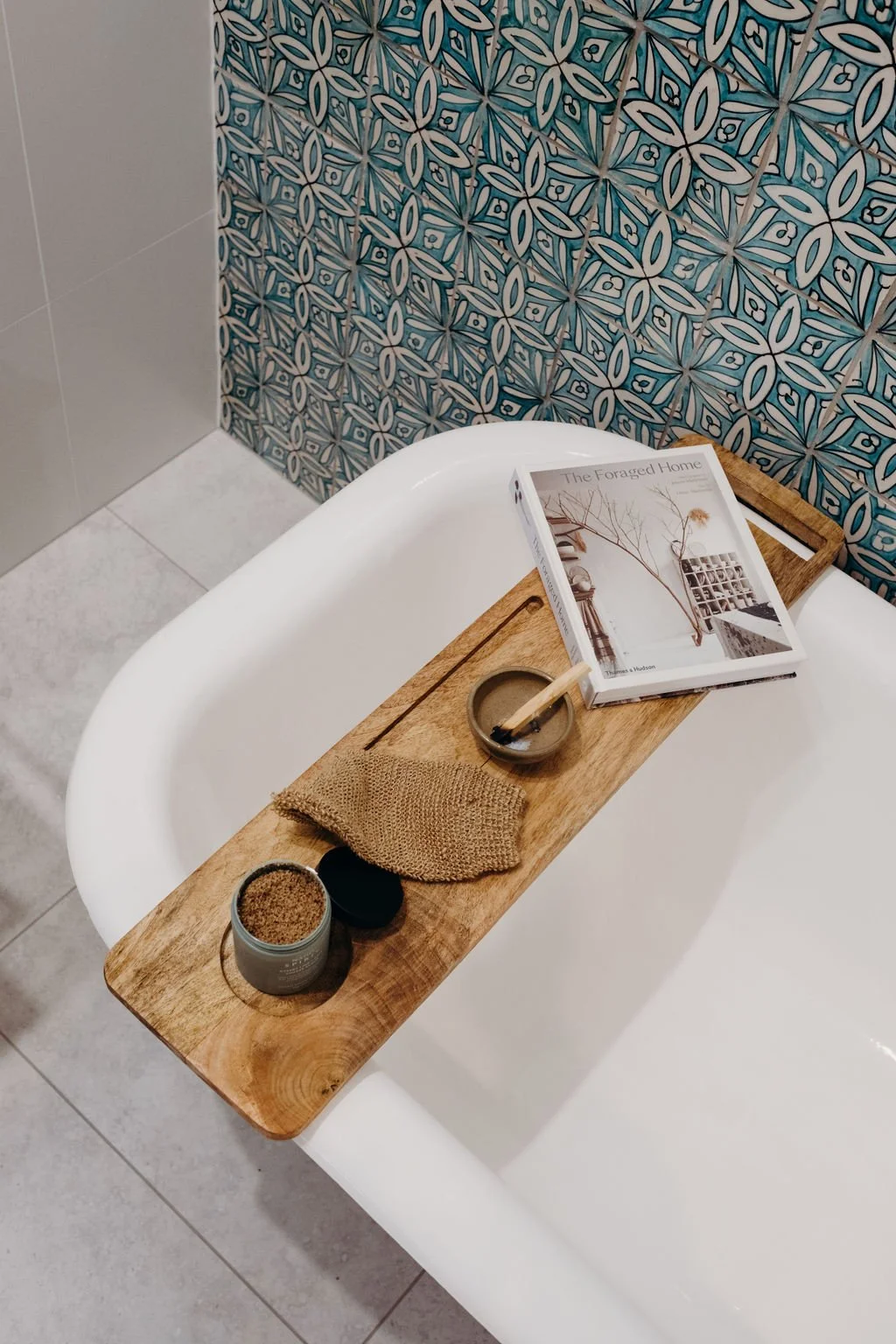 Finished bathroom by Hill House Design & Construct featuring a freestanding bathtub styled with a timber bath board and candles.