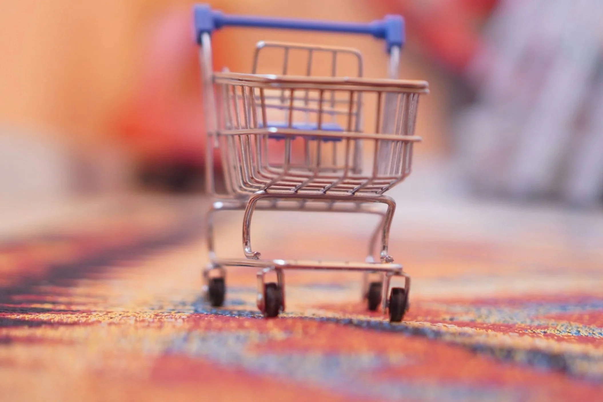 小さなショッピングカートのミニチュア模型が焦点で、背景はぼやけている