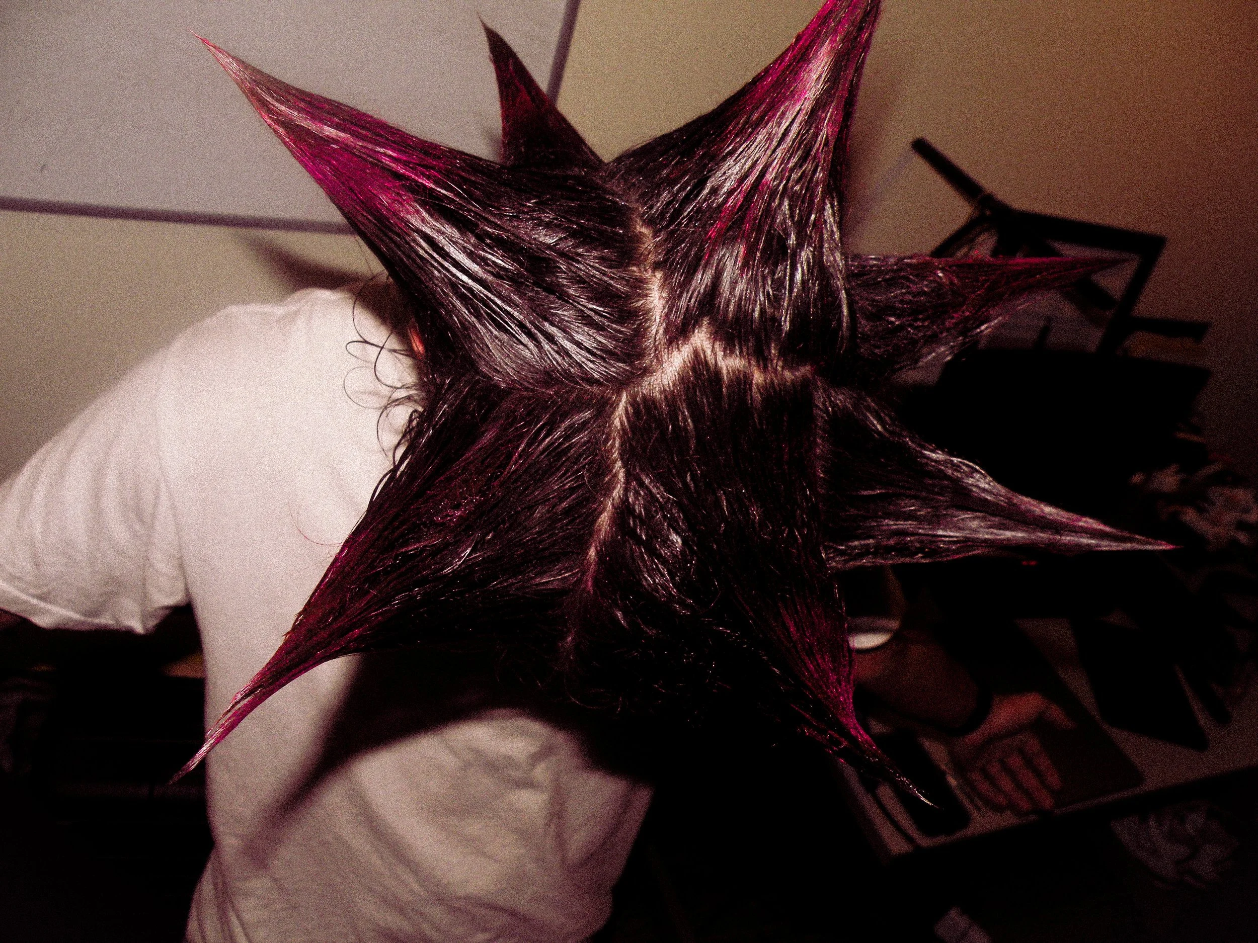 Person with long, wet hair styled into large, pointed spikes.