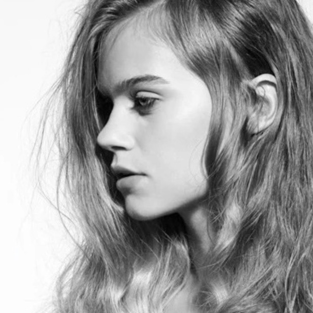 Black and white close-up portrait of a young woman with wavy hair, looking to the left. Fernando Cellini Ottawa.