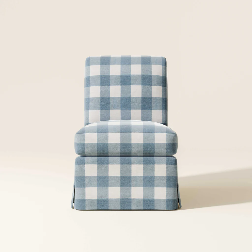 A blue and white checkered upholstered chair with a skirted bottom, set against a plain off-white background.