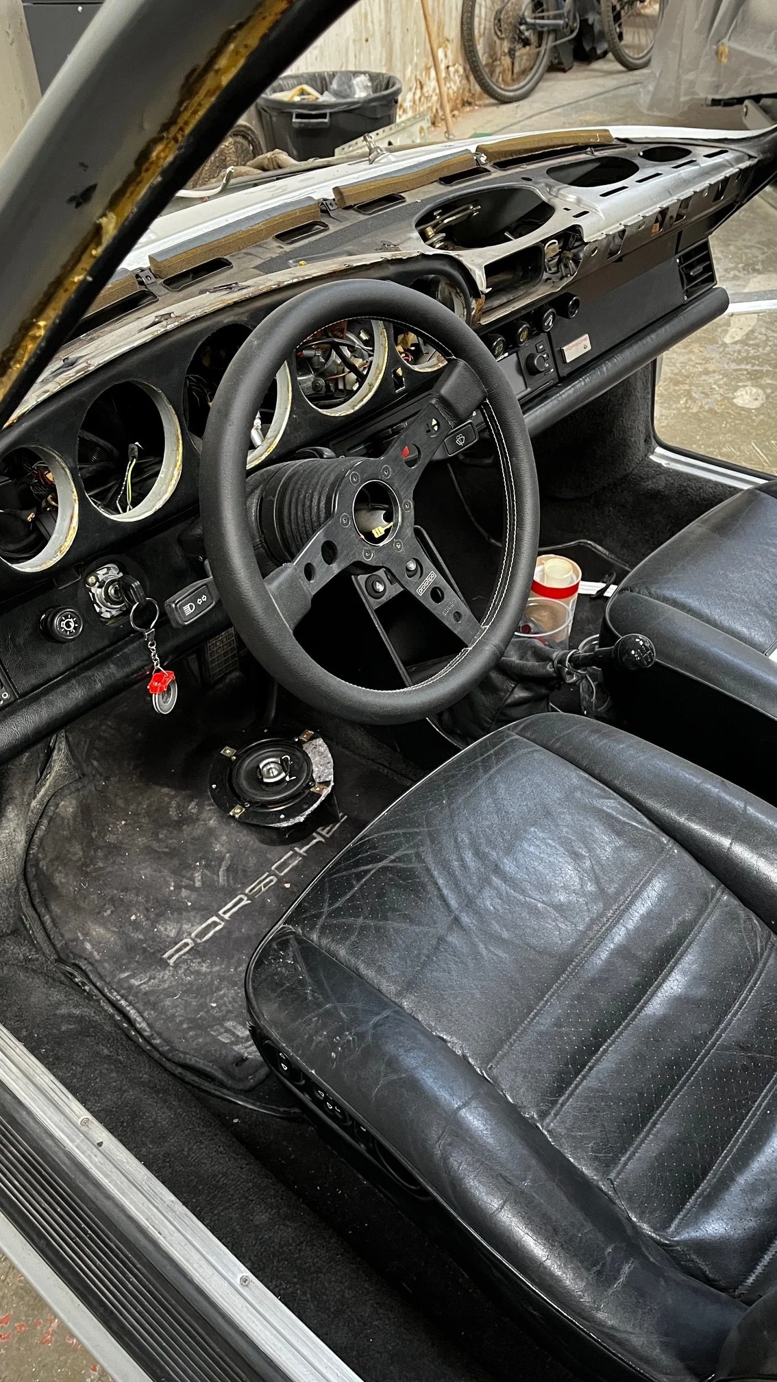 Intérieur d’une voiture de course avec tableau de bord dégarni et siège en cuir usé.
