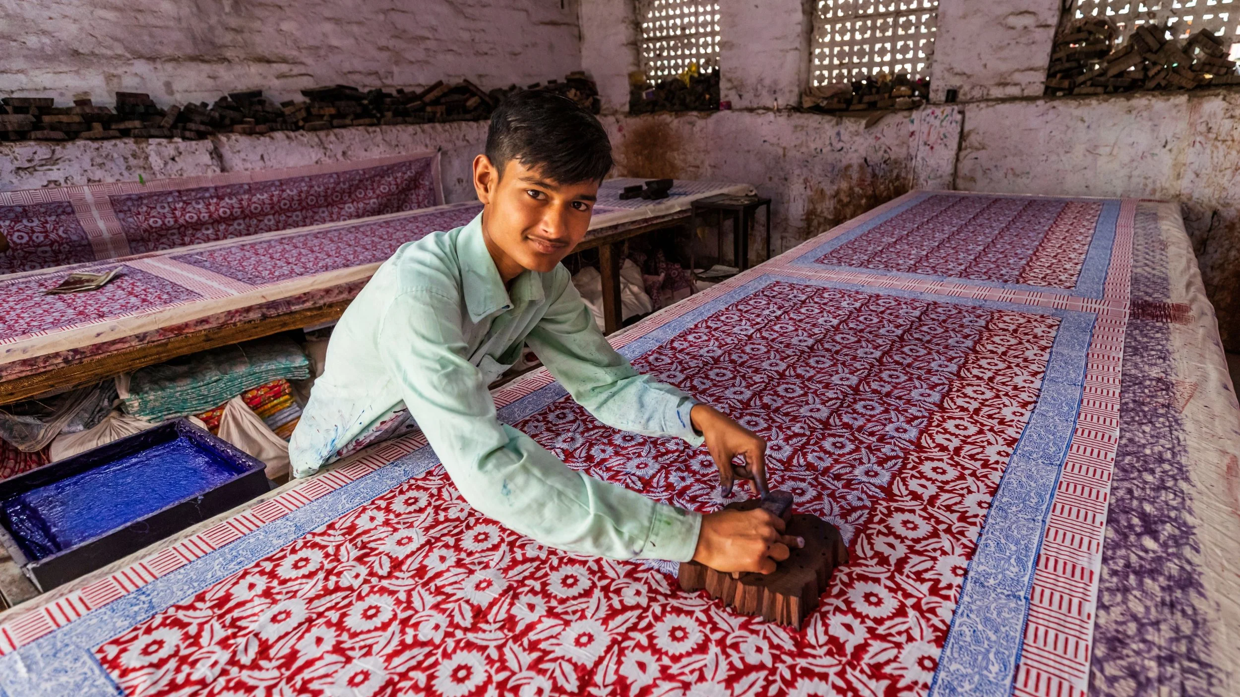 Artisan in India hand-printing fabric using traditional wooden block printing techniques