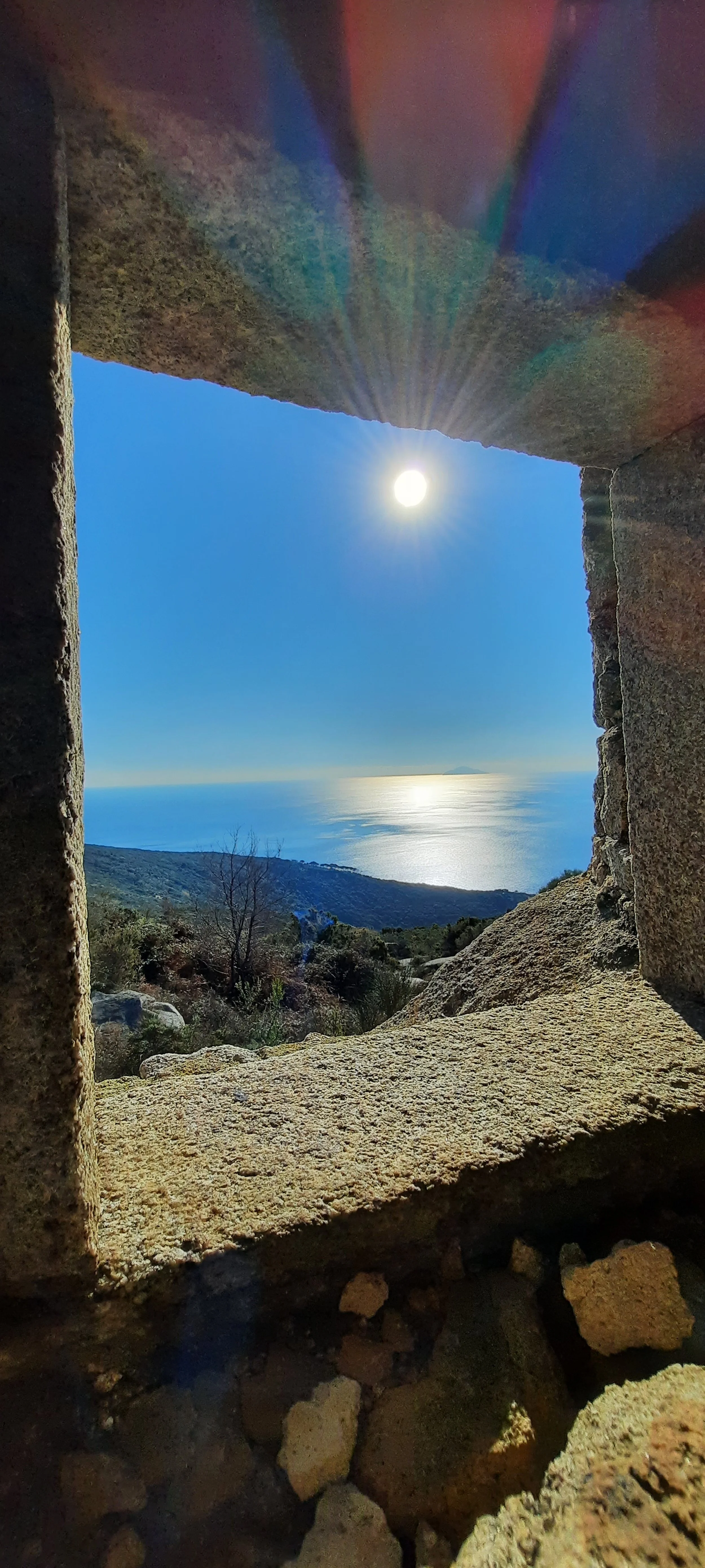 Vista del mare e del paesaggio circostante attraverso una finestra naturale creata tra le rocce