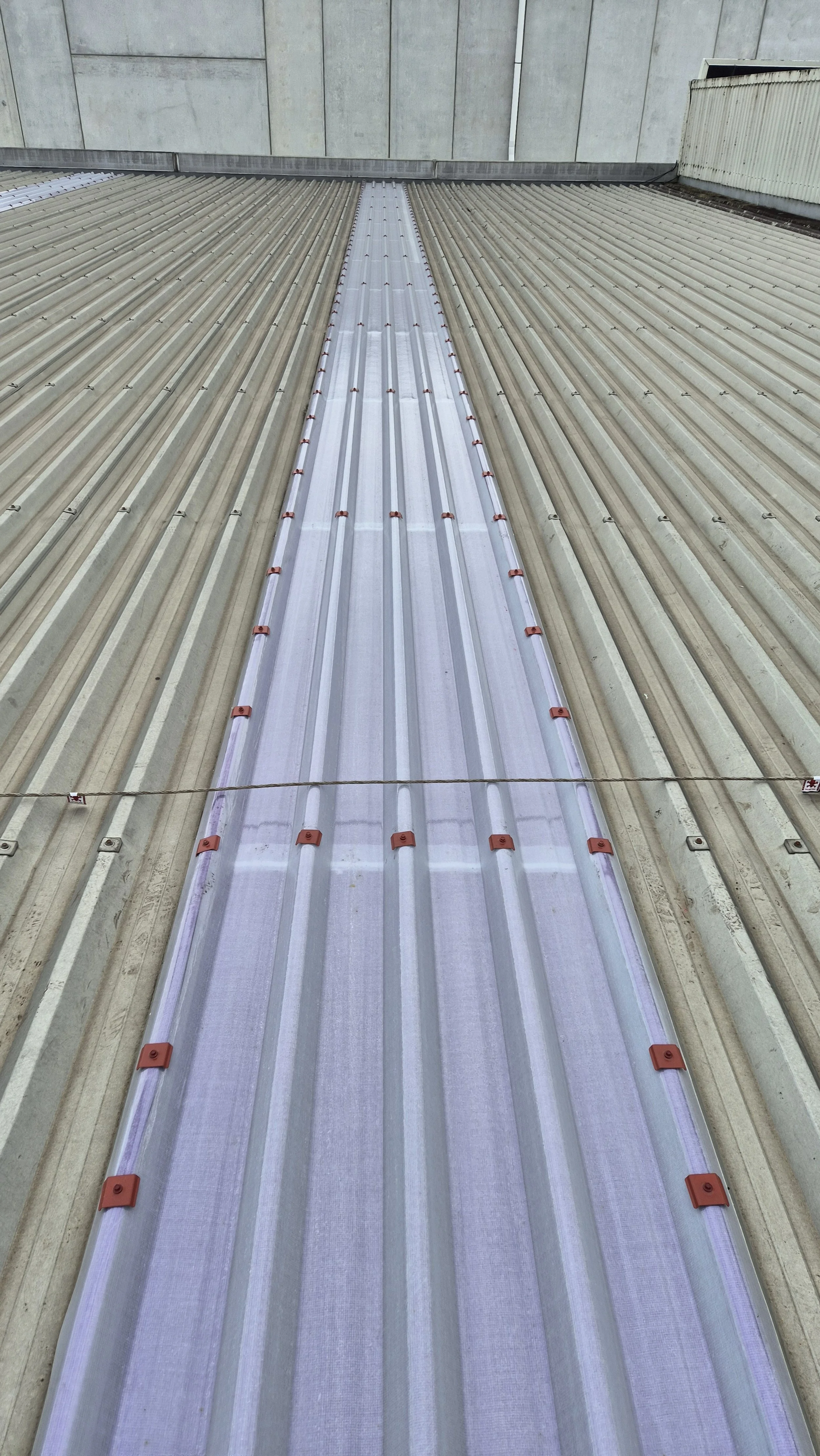 A metal roof with a central solar panel installed.