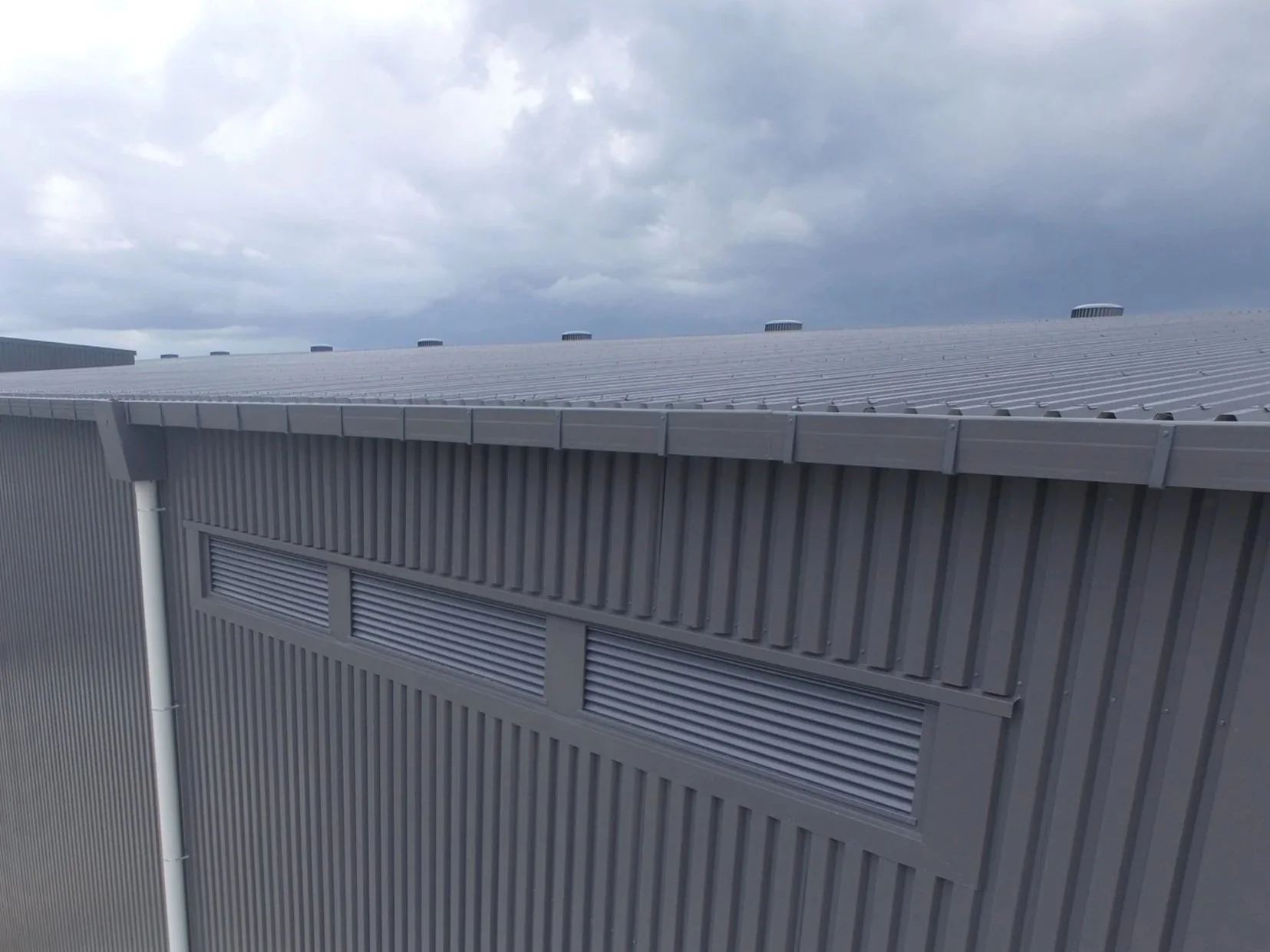 Metal box gutter with external gutter brackets. Metal rain water head and PVC downpipes.