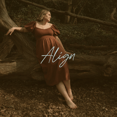 A woman in a brown dress sitting barefoot on a fallen tree in a forest, with the word 'Align' written across the image.