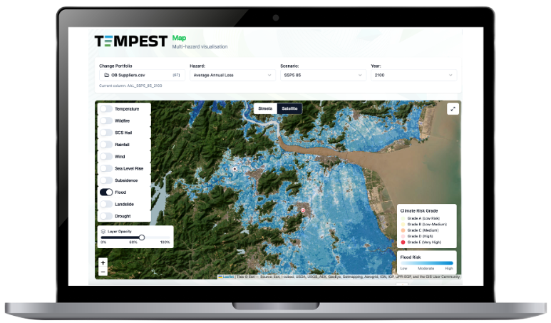 Laptop displaying a climate and flood risk map with color-coded flood risk levels and options for viewing temperature, wildfire, rainfall, wind, sea level rise, flood, landslide, and drought layers.