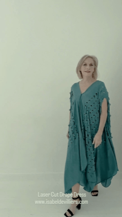 MARIETA Ferreira from AURA Models with short blonde hair wearing a teal laser-cut draped dress set against a plain light background.