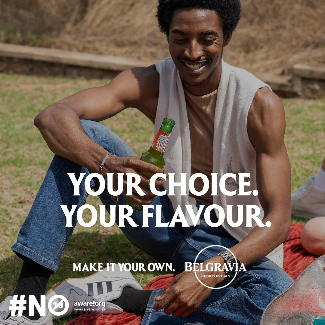 KUNDAI Madhandara from AURA Models sitting outdoors on grass, holding a bottle of beer and smiling, with text overlay saying "Your Choice. Your Flavour." and branding for Belgravia London Dry Gin.