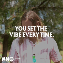 A woman with shoulder-length brown hair wearing a white and pink striped shirt standing outdoors in front of trees, with text overlay saying 'You set the vibe every time'.