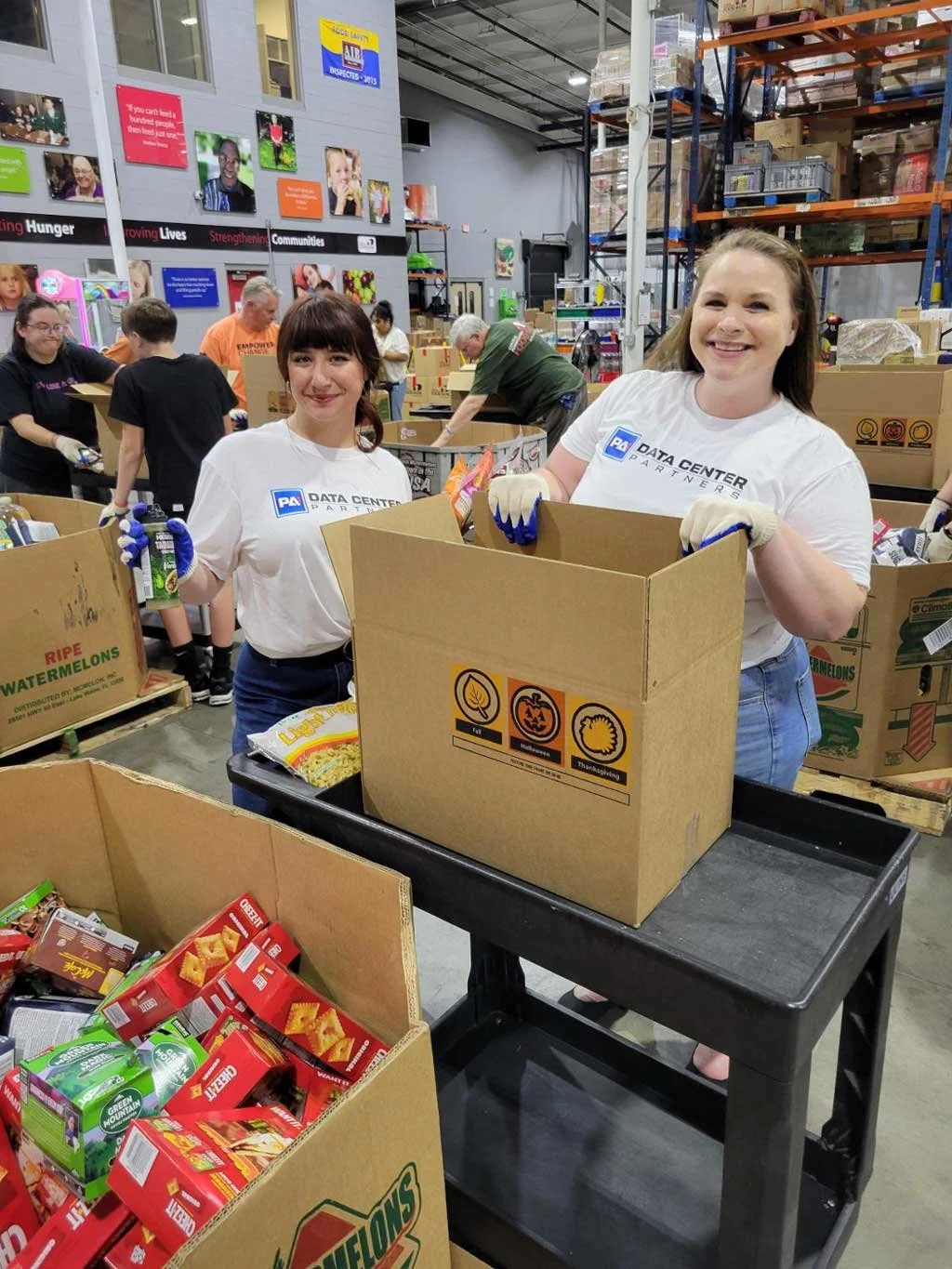 Pennsylvania Data Center Partners team members Carolina Feibush, Vice President of Community Engagement, and Brittany Hackenberg, Operations Executive, packed boxes of food that were sent to food pantries across Central Pennsylvania.