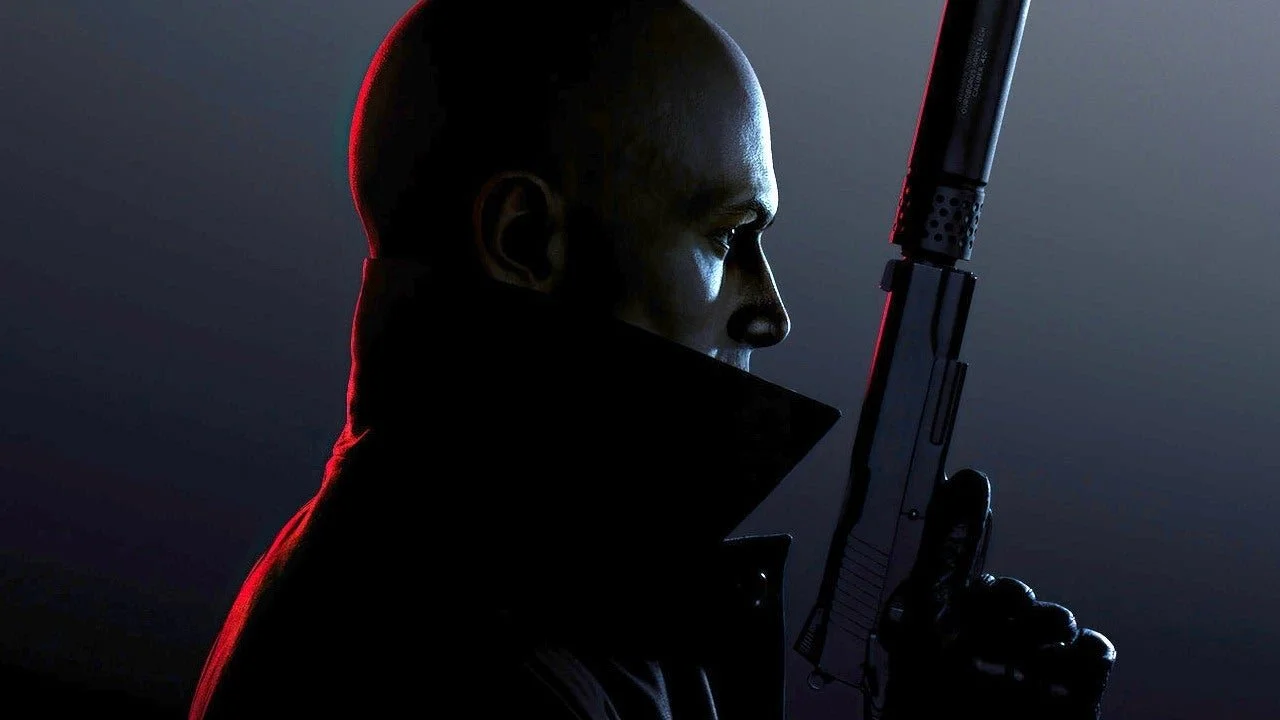 A man in dark clothing holding a futuristic gun against a dark background, illuminated by red and blue lighting.