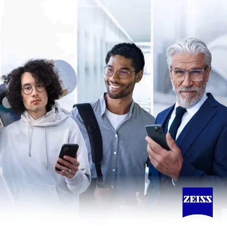 Three men standing together, looking at their smartphones, in a modern office setting with the Zeiss logo in the bottom right corner.