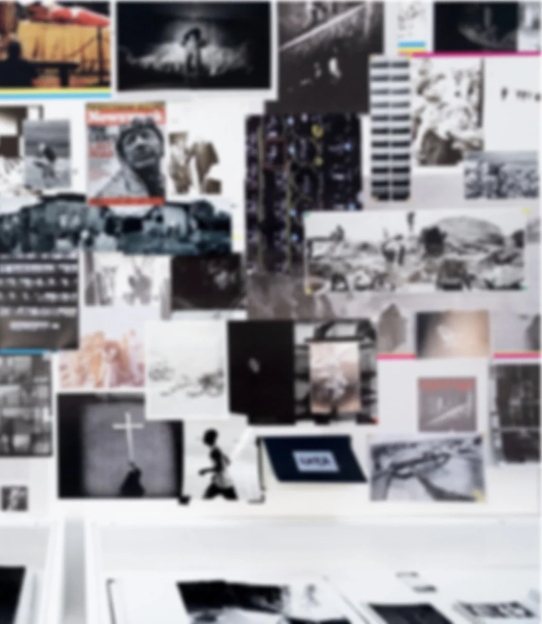 A collage of black and white historical photos and magazine covers on a wall.