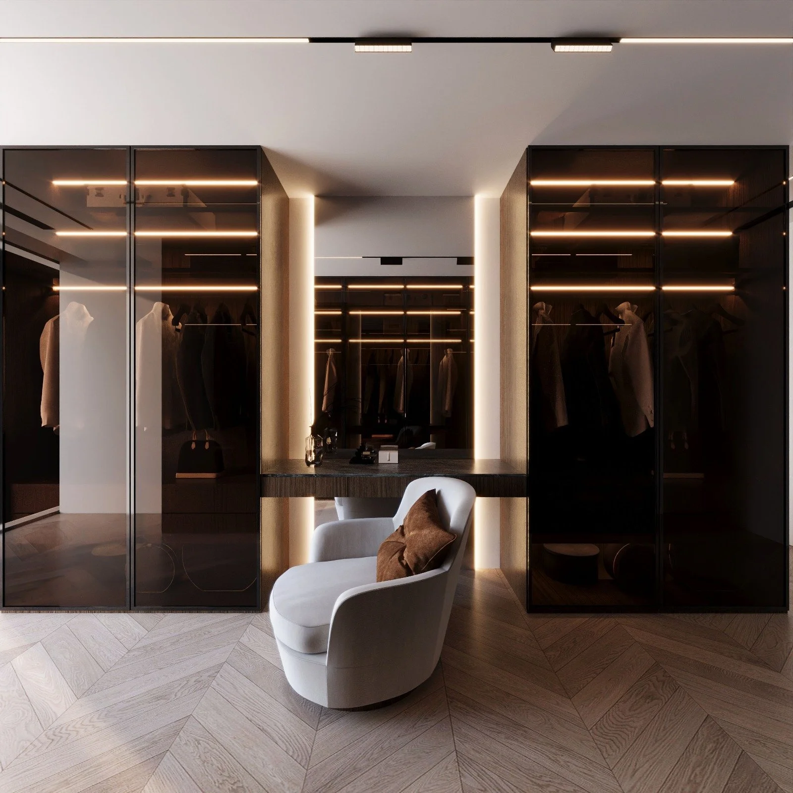 Modern walk-in closet with glass doors, black shelving, and clothing hanging inside. A white chair with a brown pillow is in front of a black desk, illuminated with warm lighting.