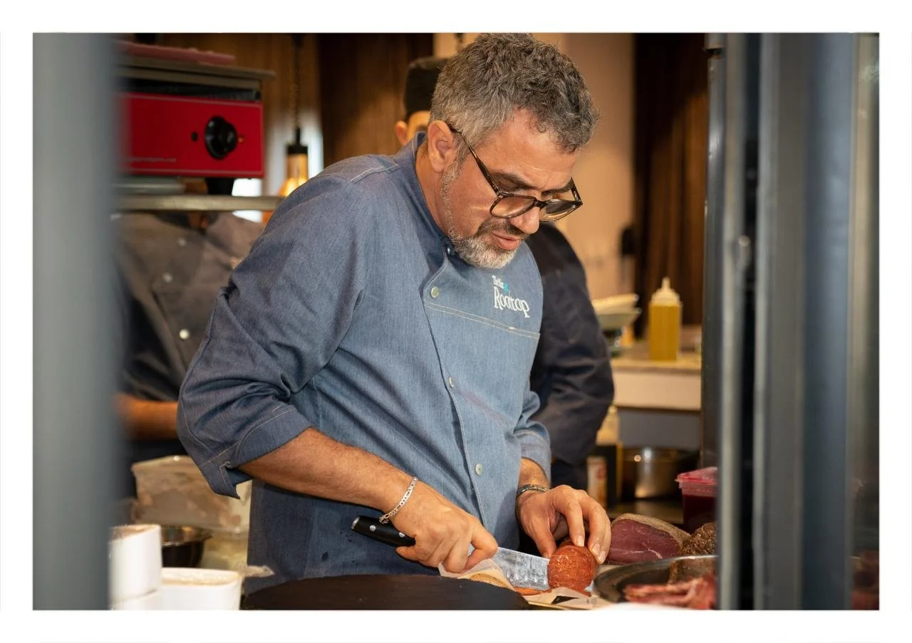 Un chef en train de couper de la viande dans une cuisine