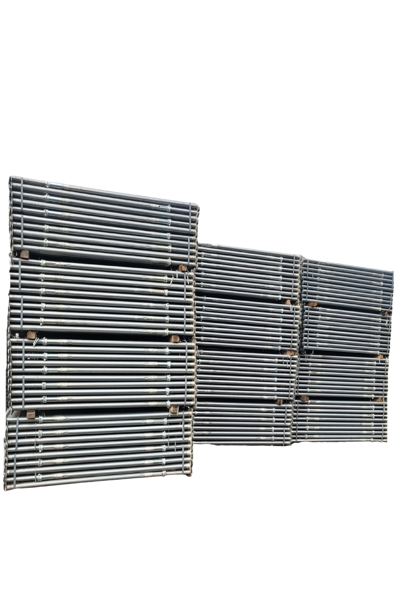 Stacks of metal pipes arranged on wooden pallets at an industrial site.