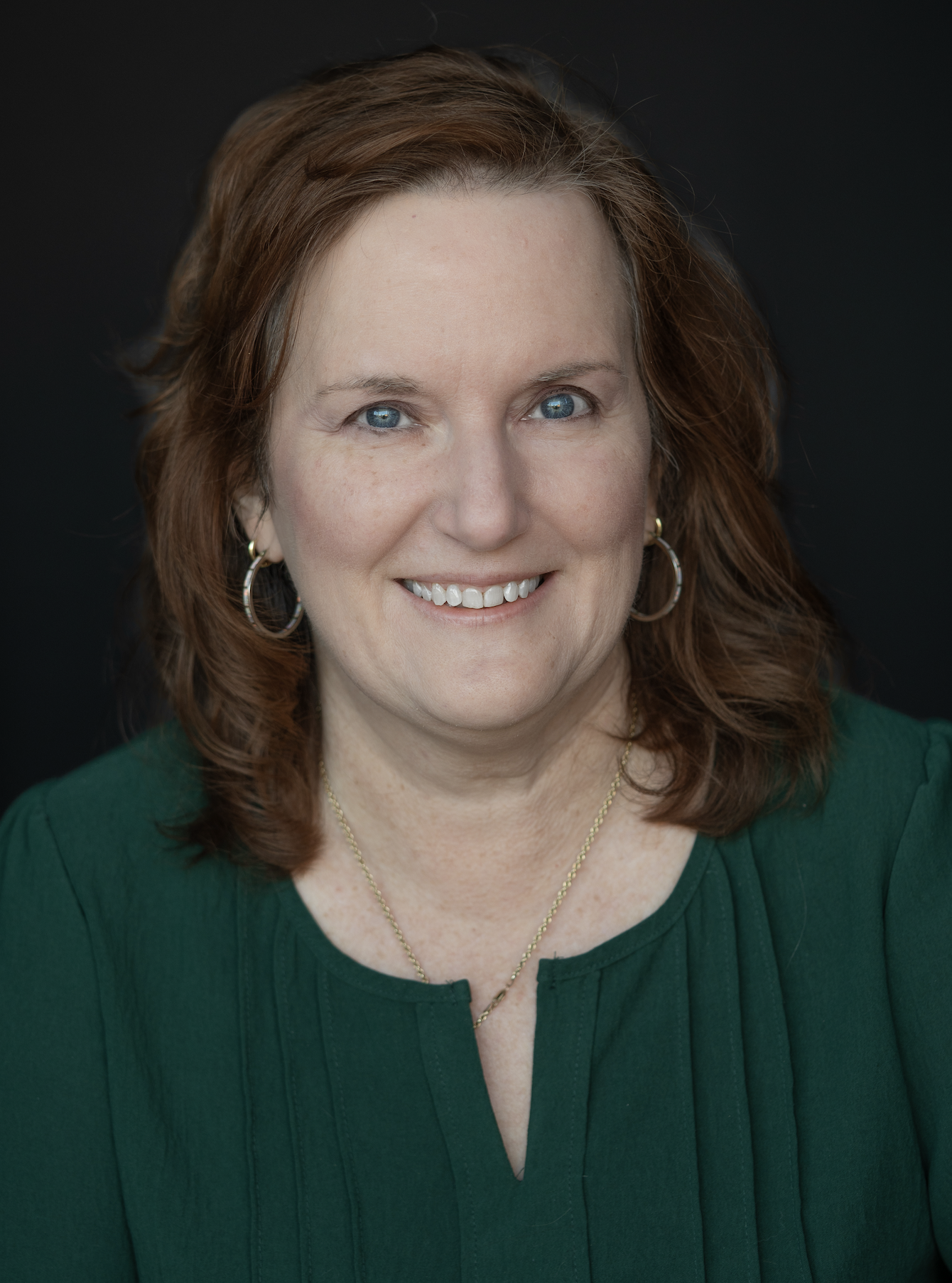a brown haired woman in a green blouse