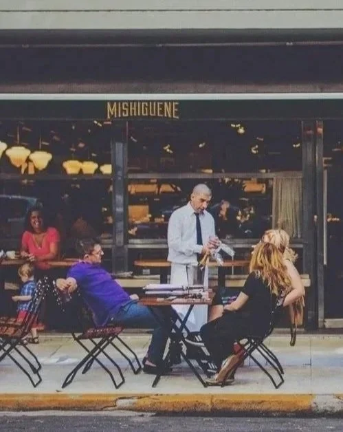 waiter chatting with quests outside bistro
