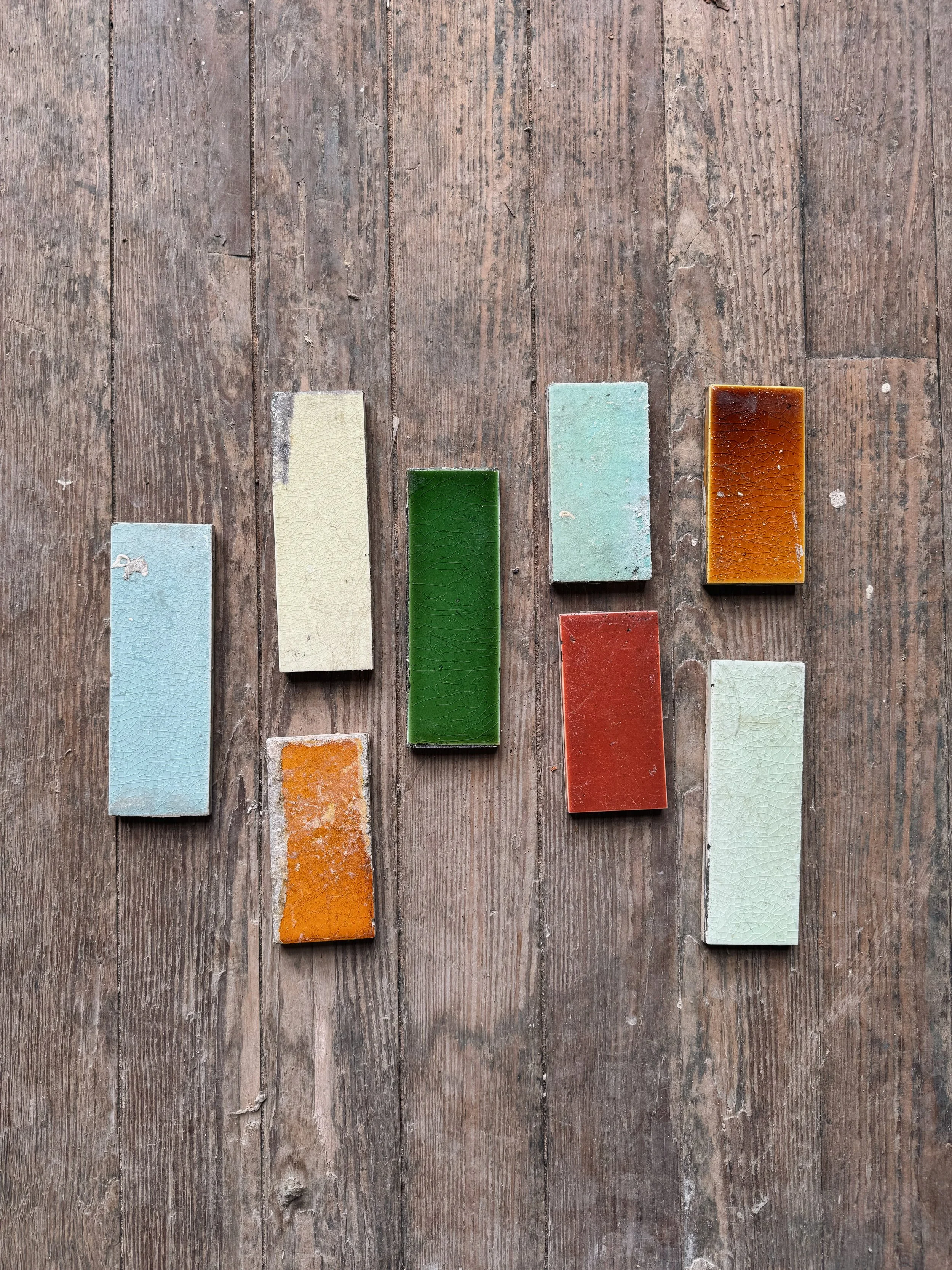 Colorful ceramic tiles arranged on a wooden surface, resembling a bar graph or equalizer display.