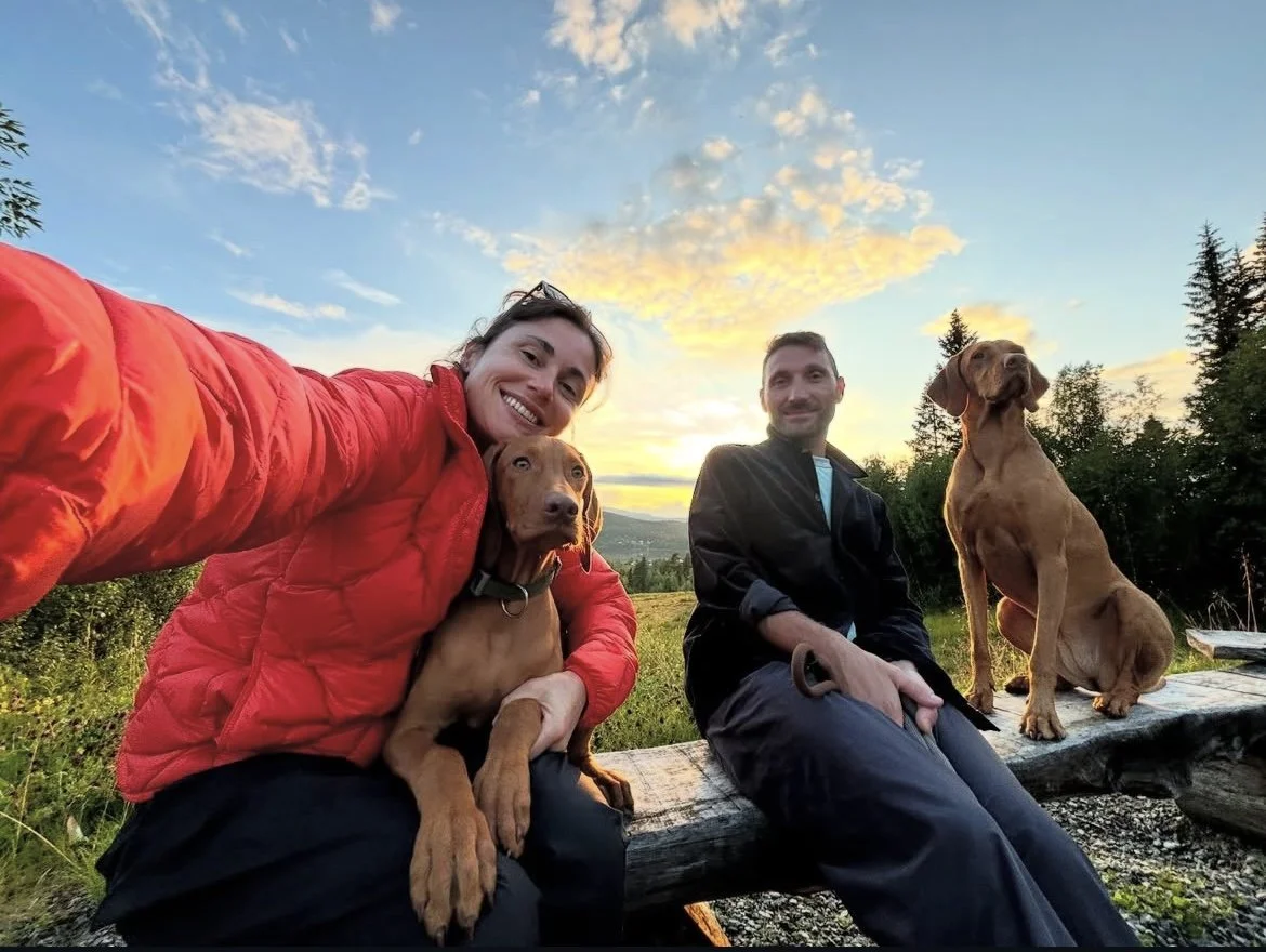 A couple on a hike with their vizslas 
