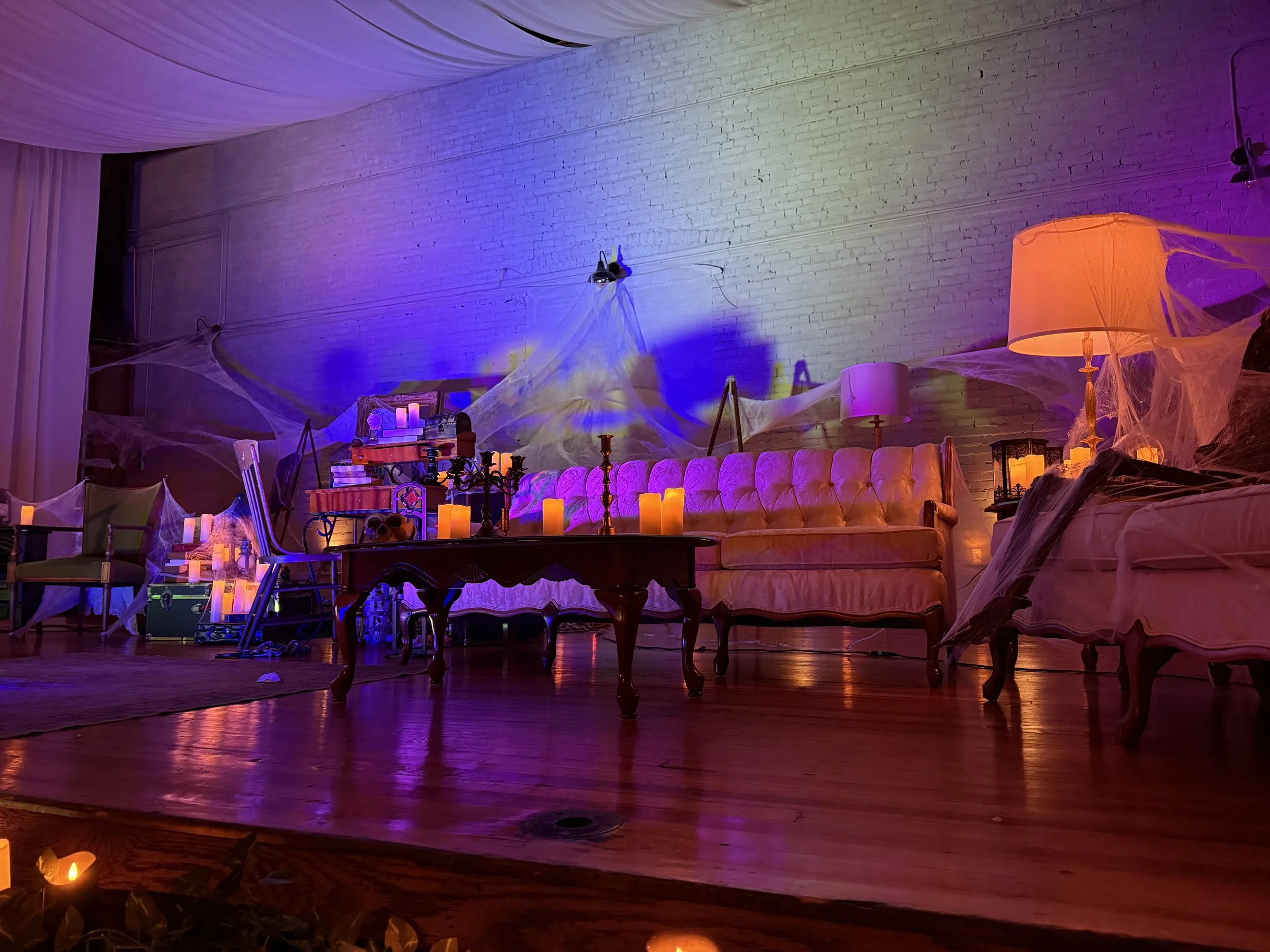 The stage at the Historic German House is decorated with antique furniture, candles, and pseudo cobwebs.