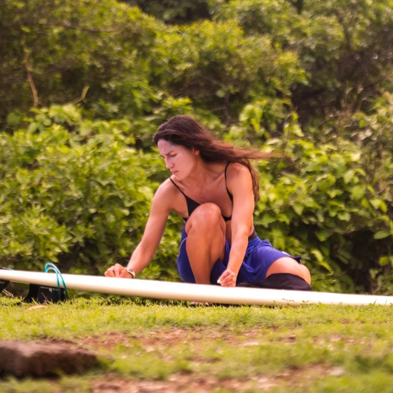 Lizzy, owner of Host Turn, waxing her surfboard