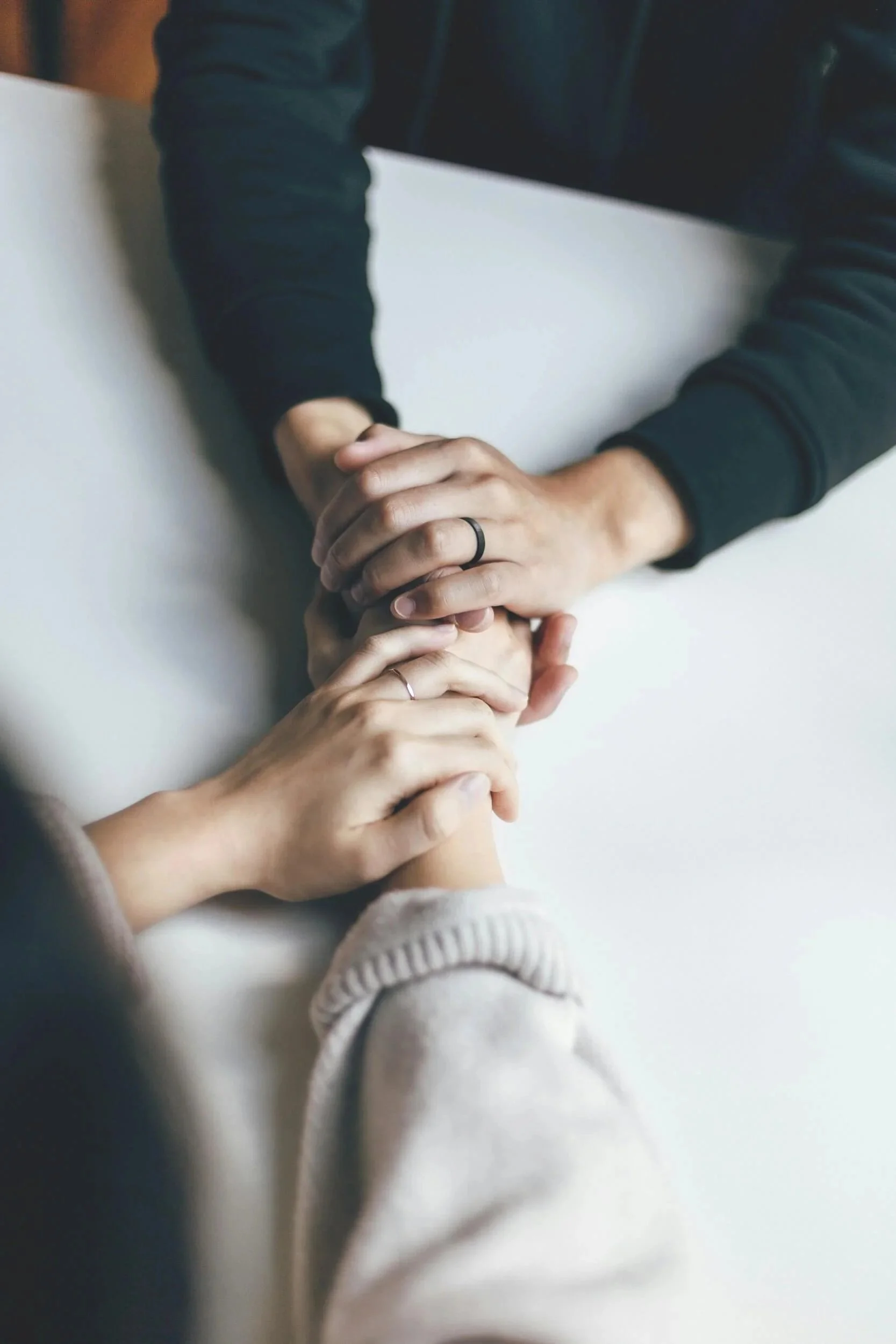 Two people holding hands learning how to be better parents from a therapist.