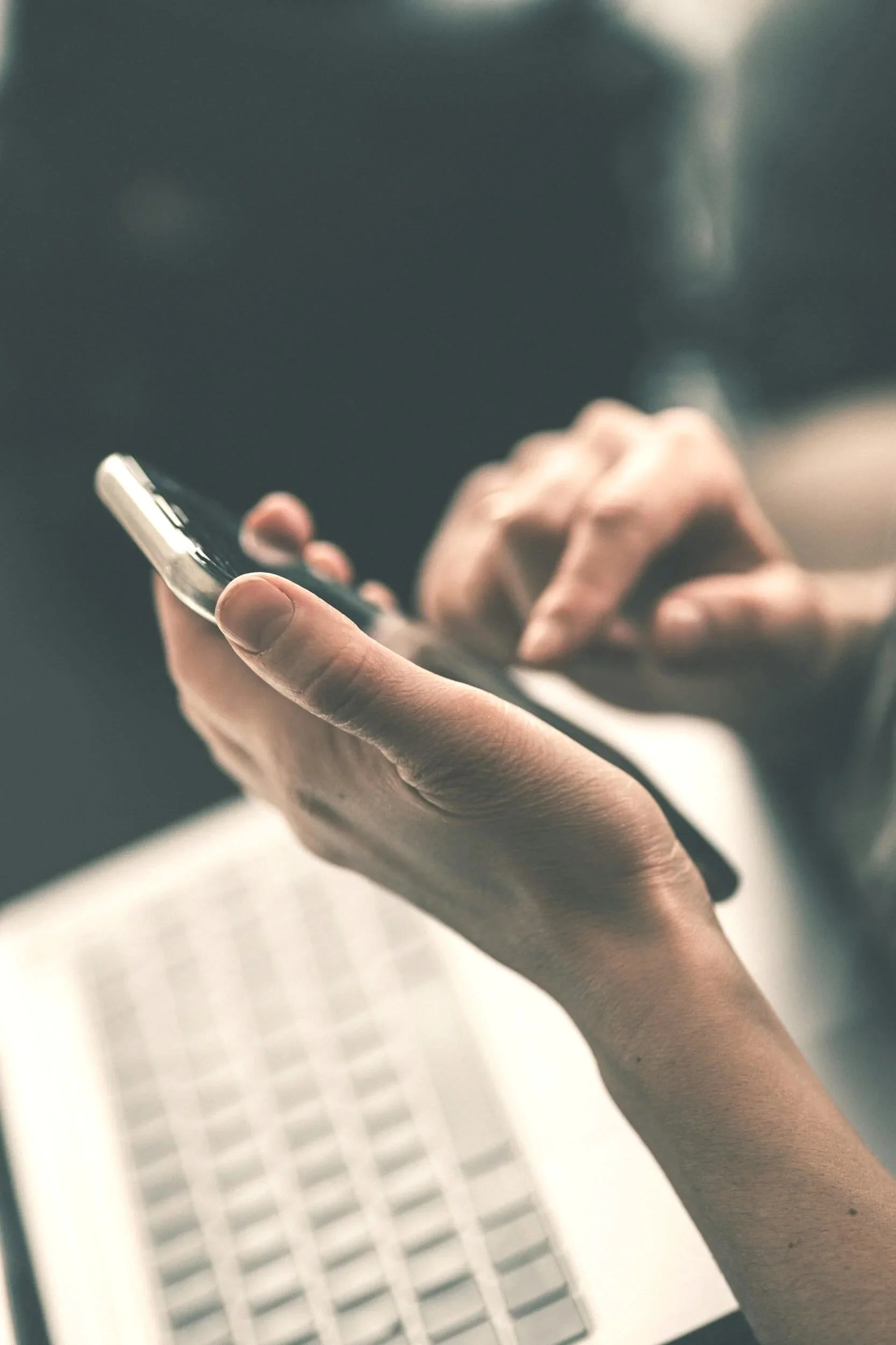 Close-up of a person holding a smartphone with one hand making an appointment with Angie Yemma for therapy.