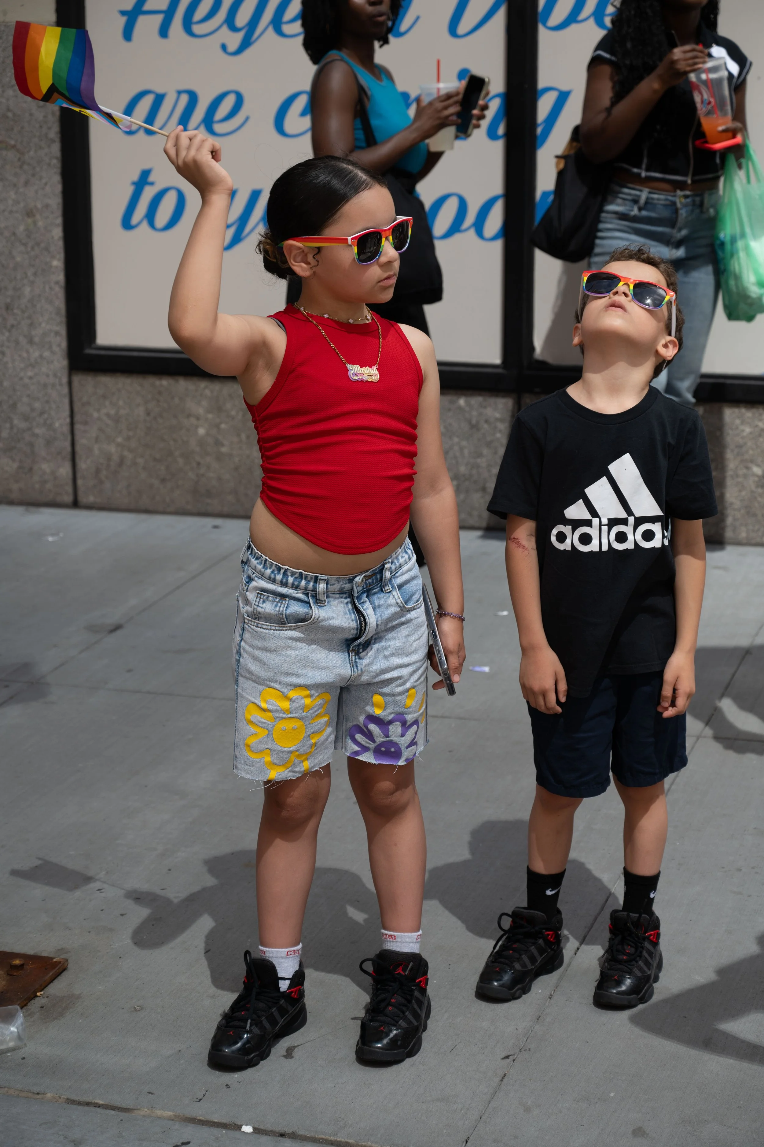 Kids wave a pride flag while waiting for NYC's annual Pride march to commence in midtown Manhattan on June 29, 2025.
