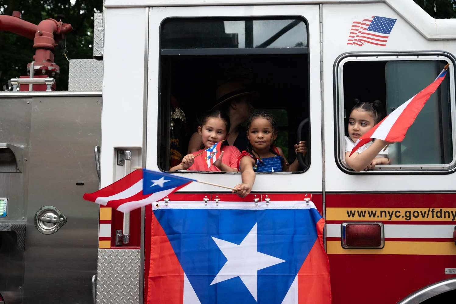 Kids wave Puerto Rican flags to the crowd during NYC's annual Puerto Rican Day Parade along Central Park on June 8, 2025.
