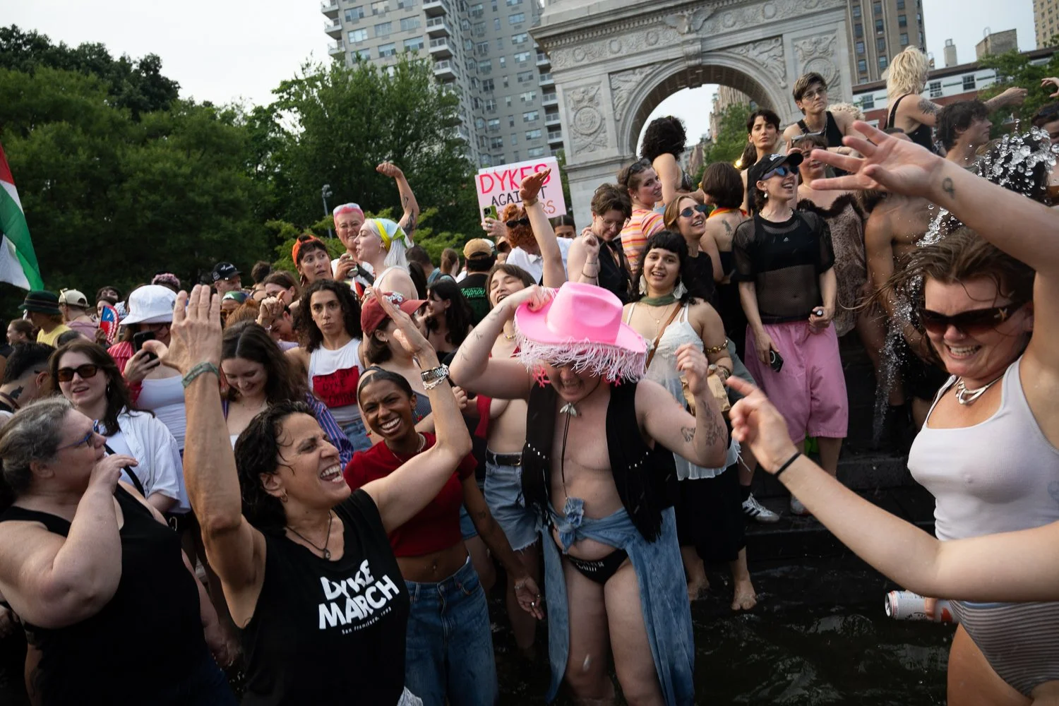 Marchers dance to pop hits in the Washington Square Park fountain after walking in NYC's Dyke March on June 28, 2025.