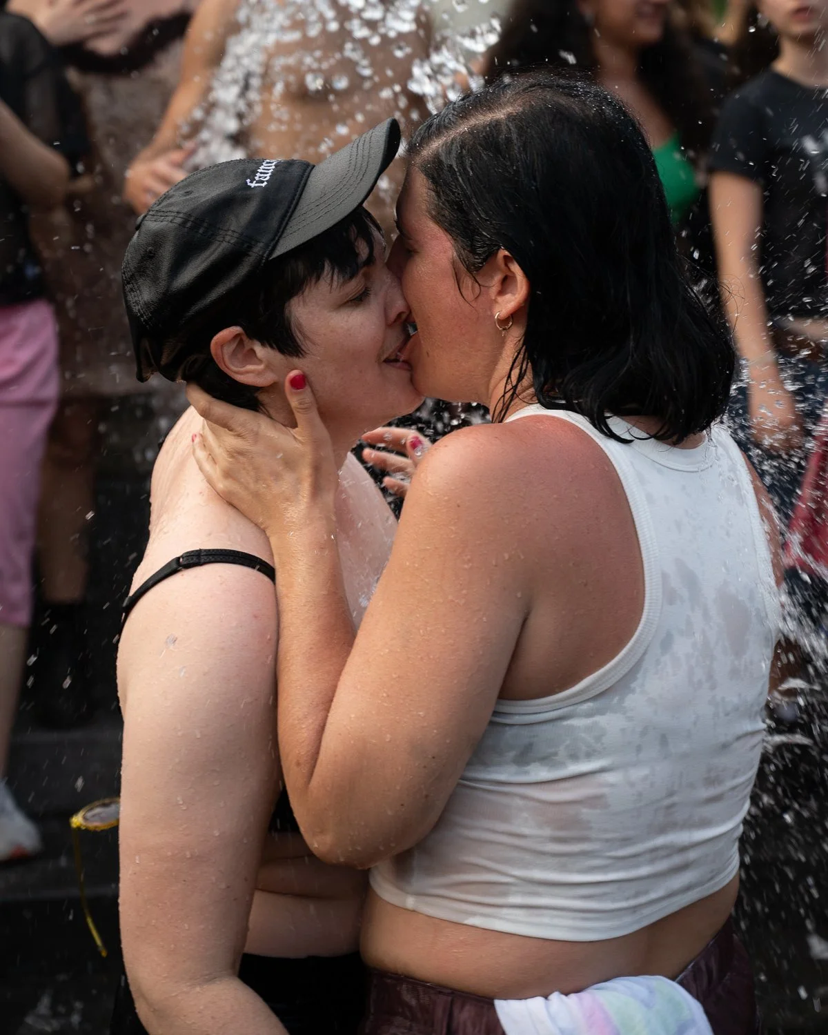A couple kisses in the Washington Square Park fountain after walking in NYC's annual Dyke March on June 28, 2025.