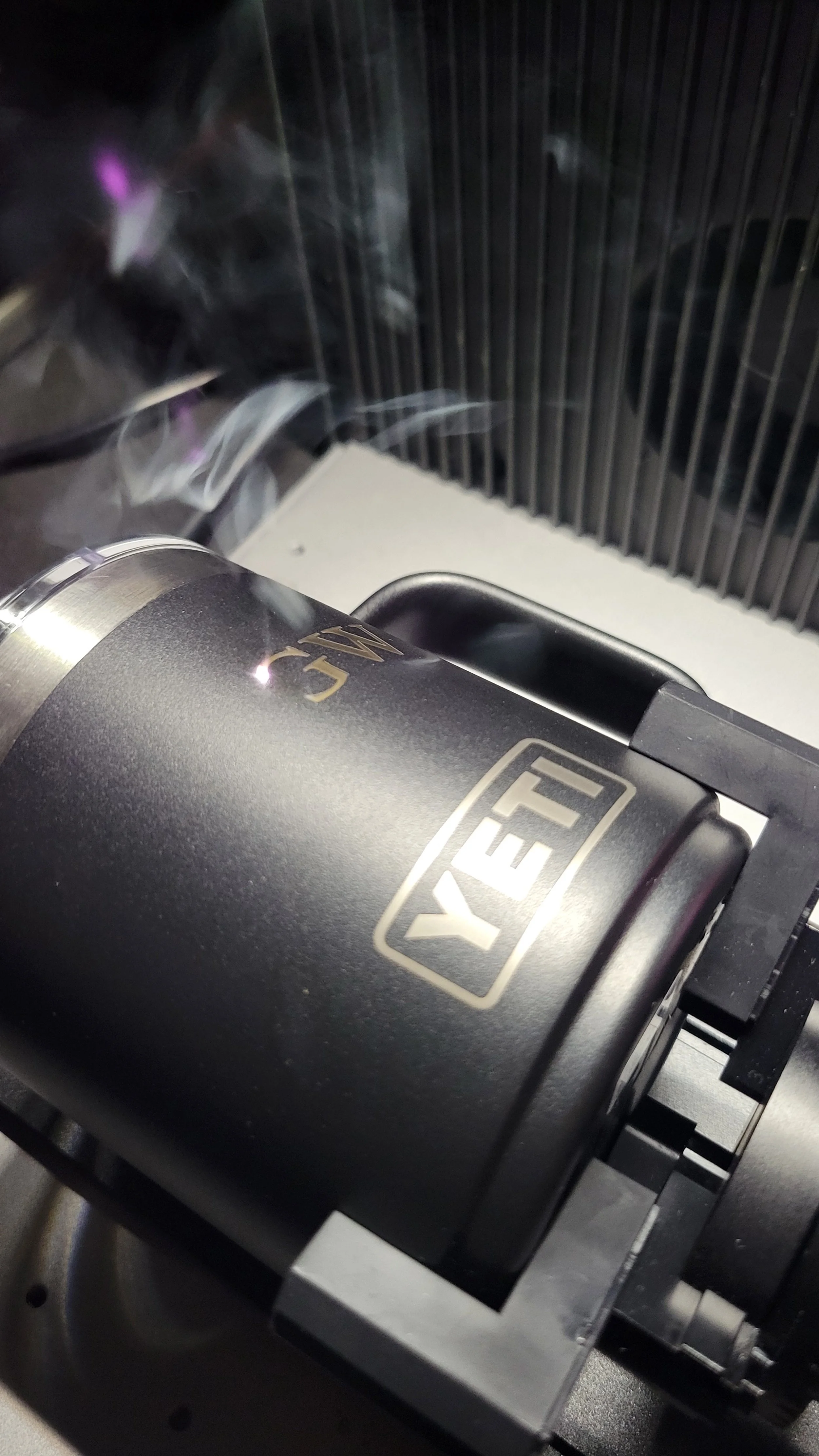 Live laser engraving of stainless steel tumblers at a corporate event in San Diego