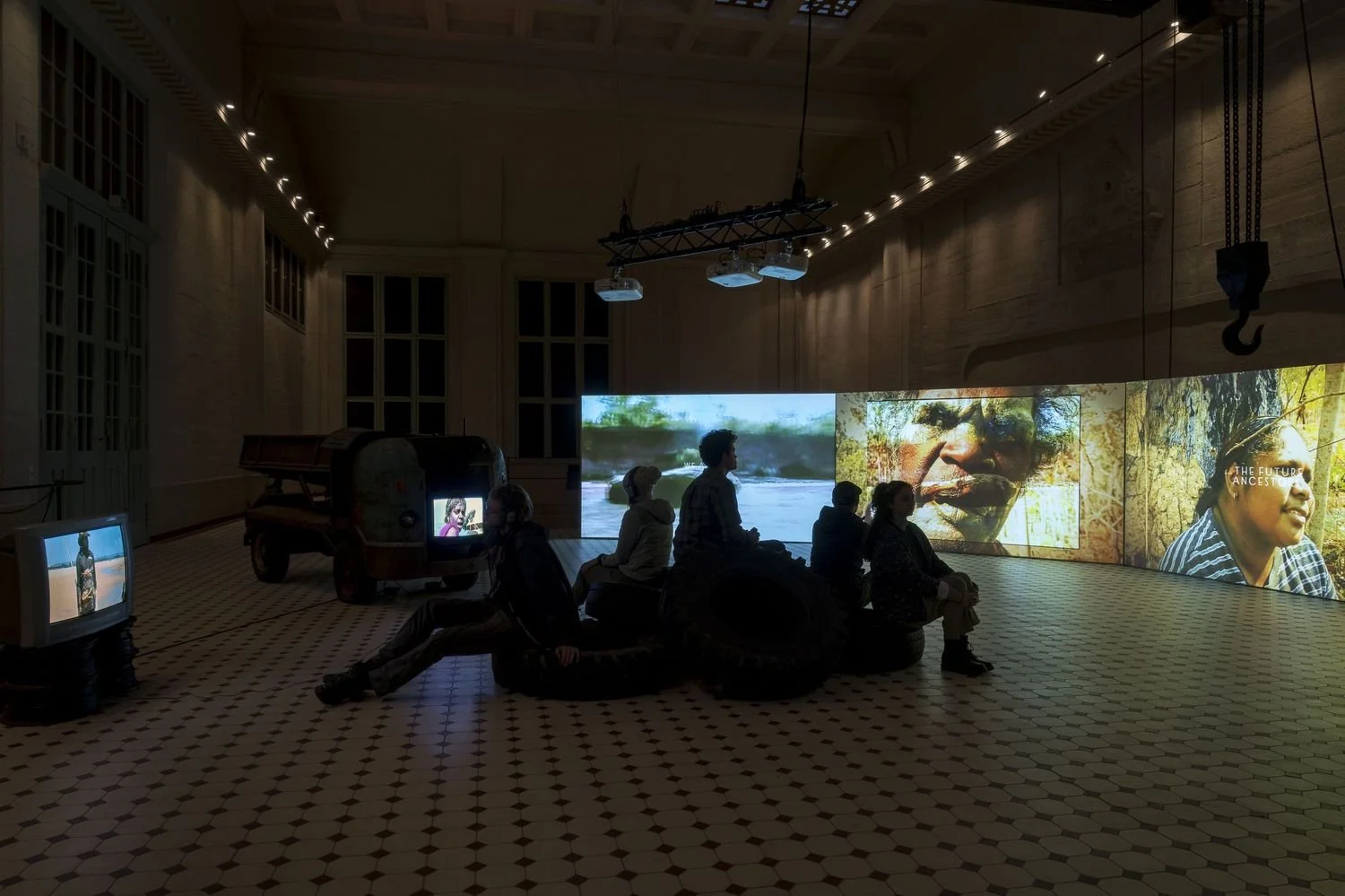 Installation view of The Family (A Zombie Movie) by Karrabing Film Collective, as part of POWER NIGHTS curated by Lucia Pietroiusti, Helen Turner, Katharina Worf and Adriana Tranca at E-WERK Luckenwalde, 2021 - 2022. Courtesy E-WERK Luckenwalde and K