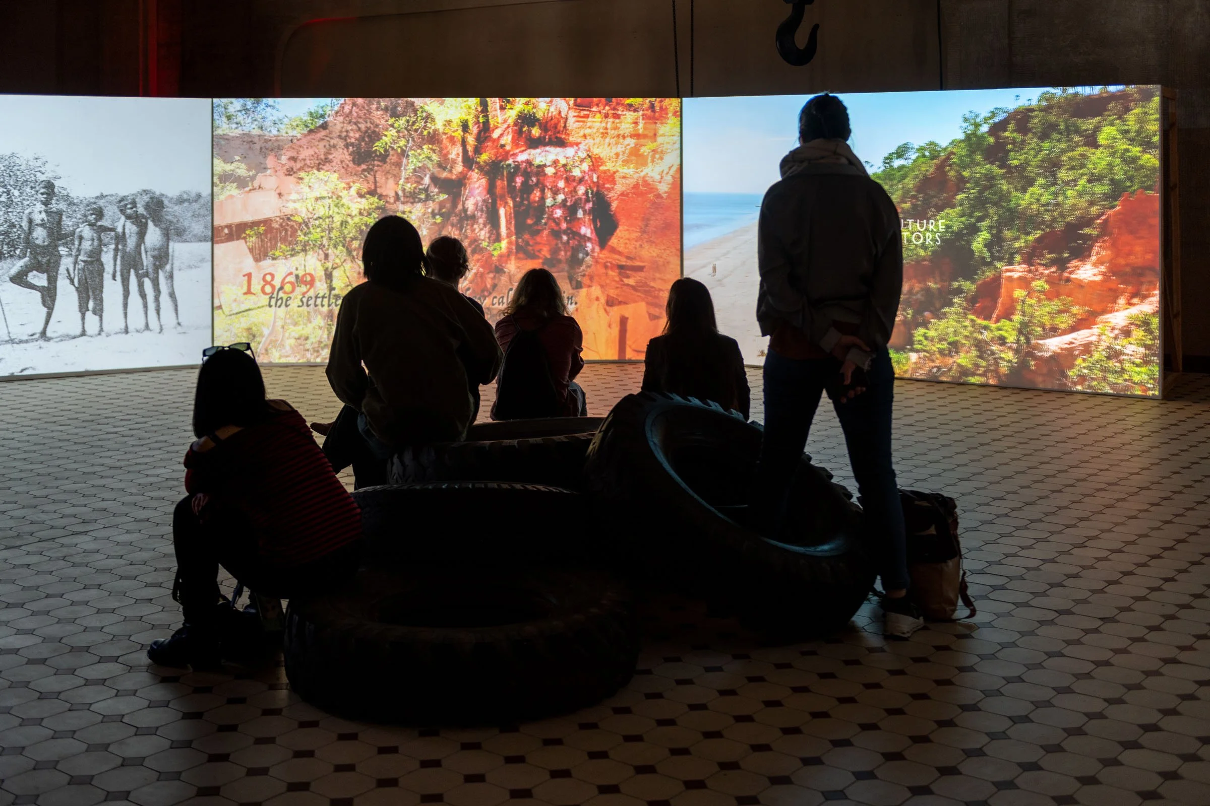 Installation view of The Family (A Zombie Movie) by Karrabing Film Collective, as part of POWER NIGHTS curated by Lucia Pietroiusti, Helen Turner, Katharina Worf and Adriana Tranca at E-WERK Luckenwalde, 2021 - 2022. Courtesy E-WERK Luckenwalde and K