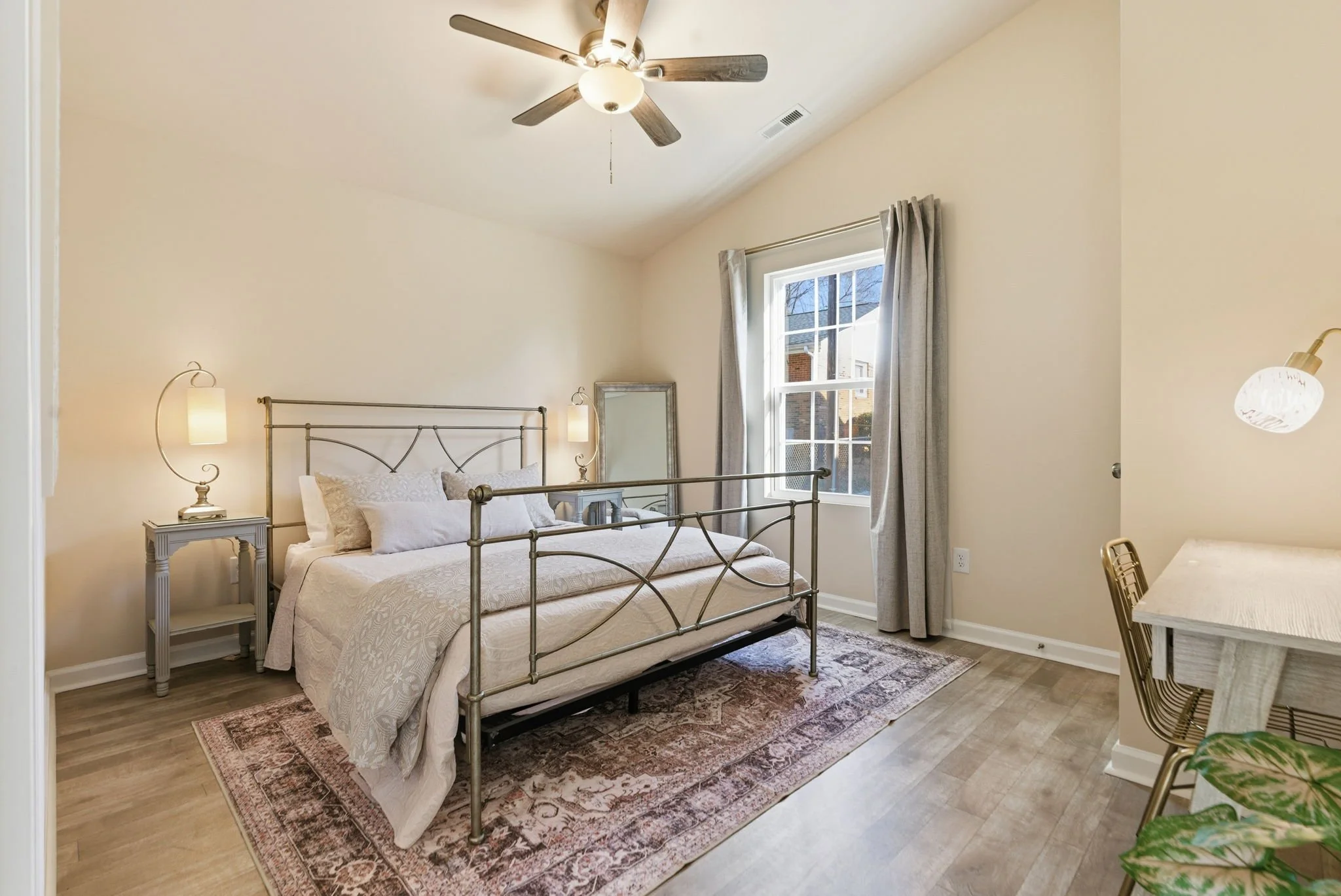 Serene primary suite with a vaulted ceiling, premium metal bed frame, and a dedicated workspace. Ideal corporate housing for RTP professionals or medical residents near Duke.